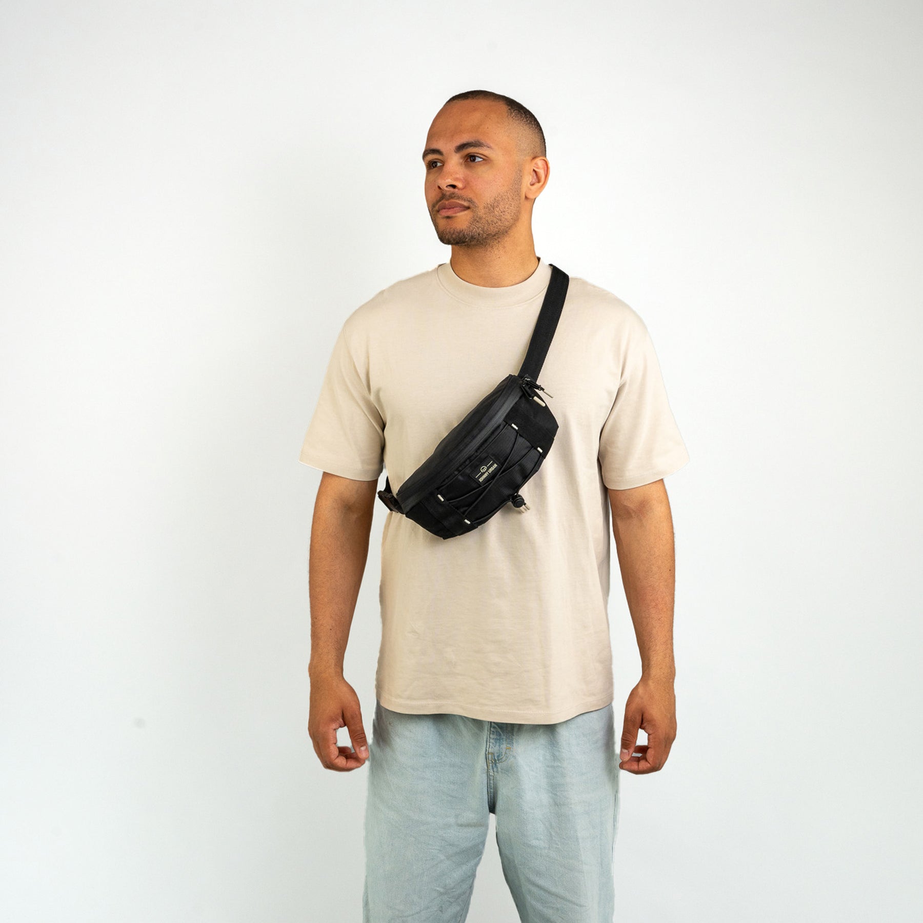 Mann trägt schwarze Bauchtasche 'Devin' von Johnny Urban quer über den Oberkörper