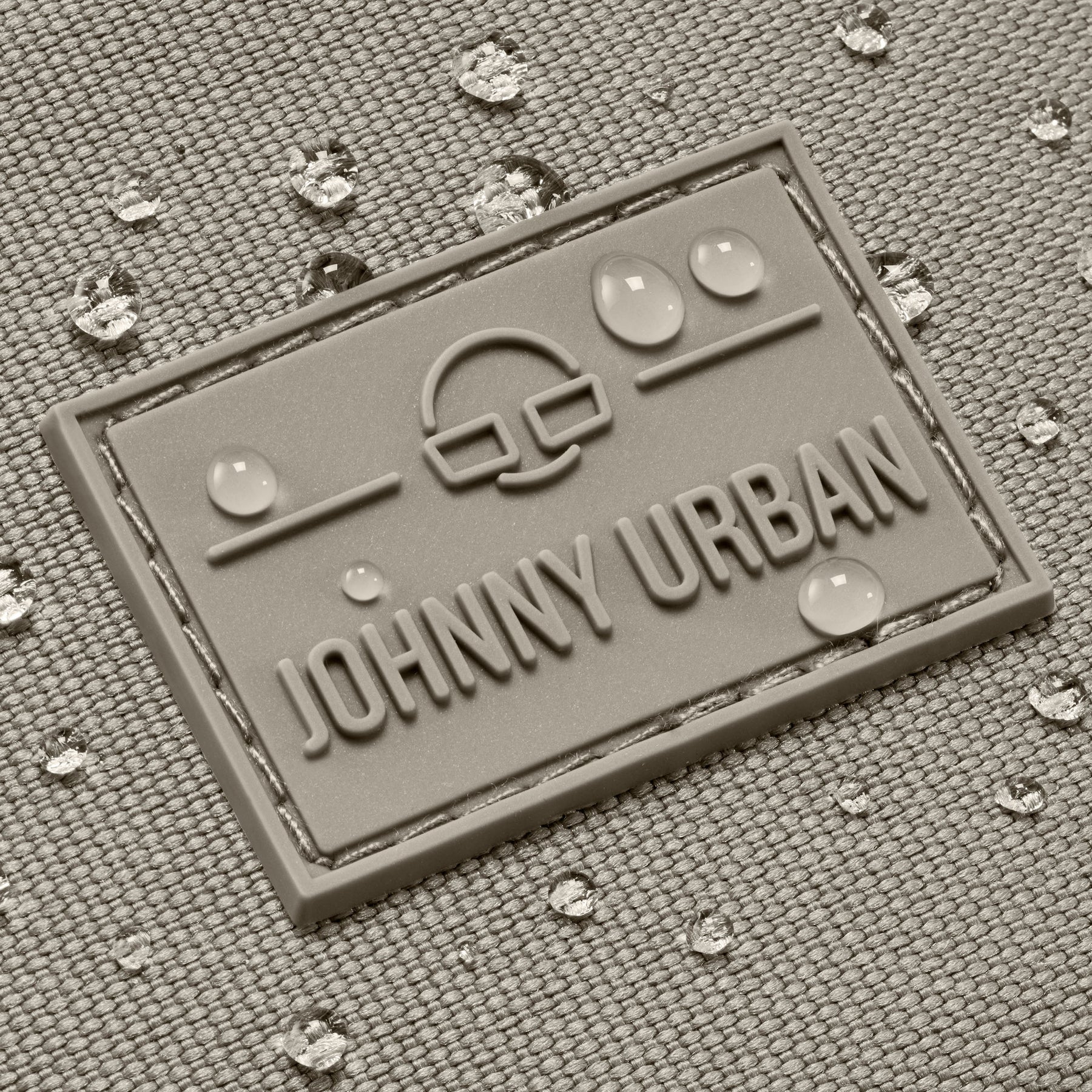 Wasserdichte Textiloberfläche mit Johnny Urban Logo und Wassertropfen