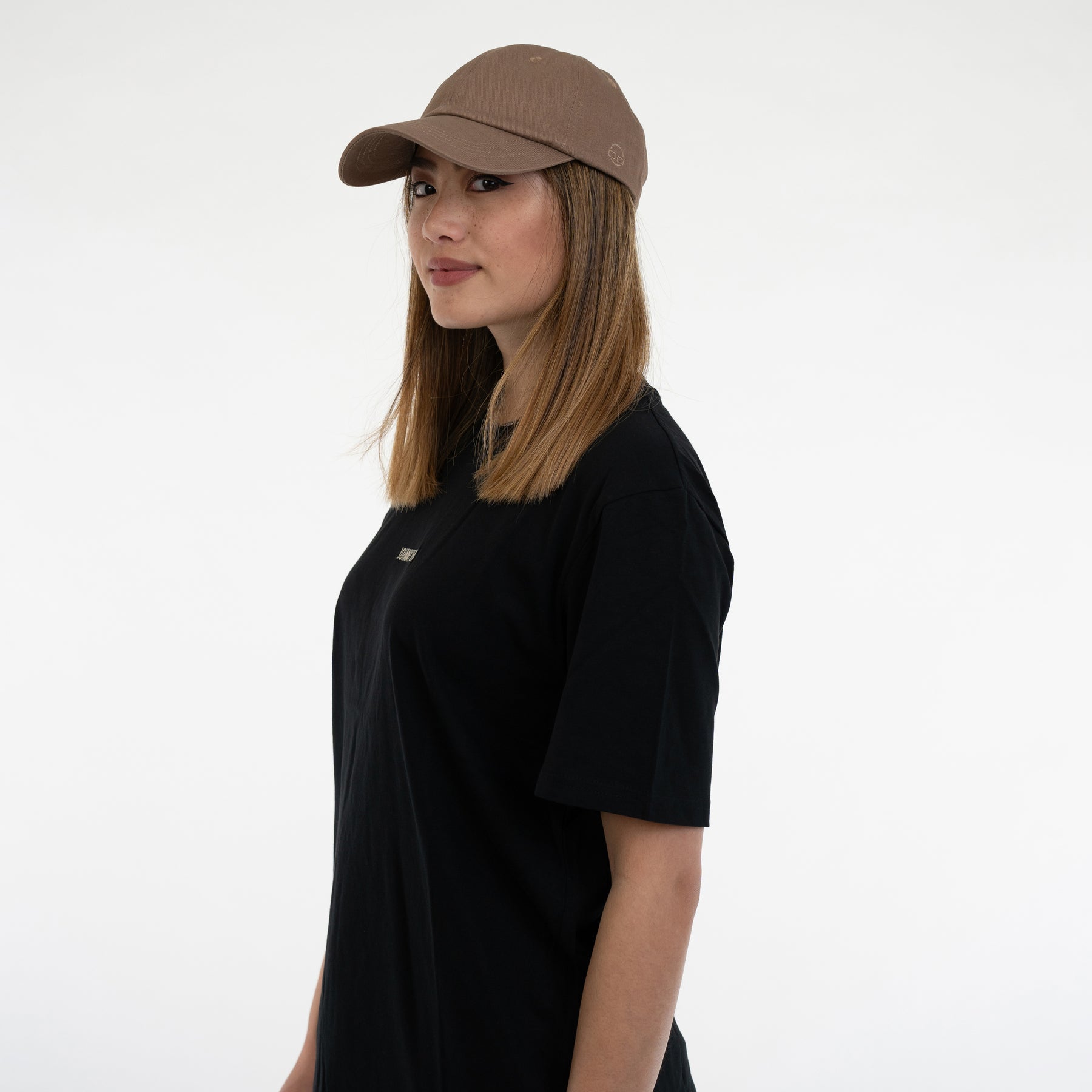 Frau mit brauner Cap 'Jen' und schwarzem T-Shirt, Seitenprofil