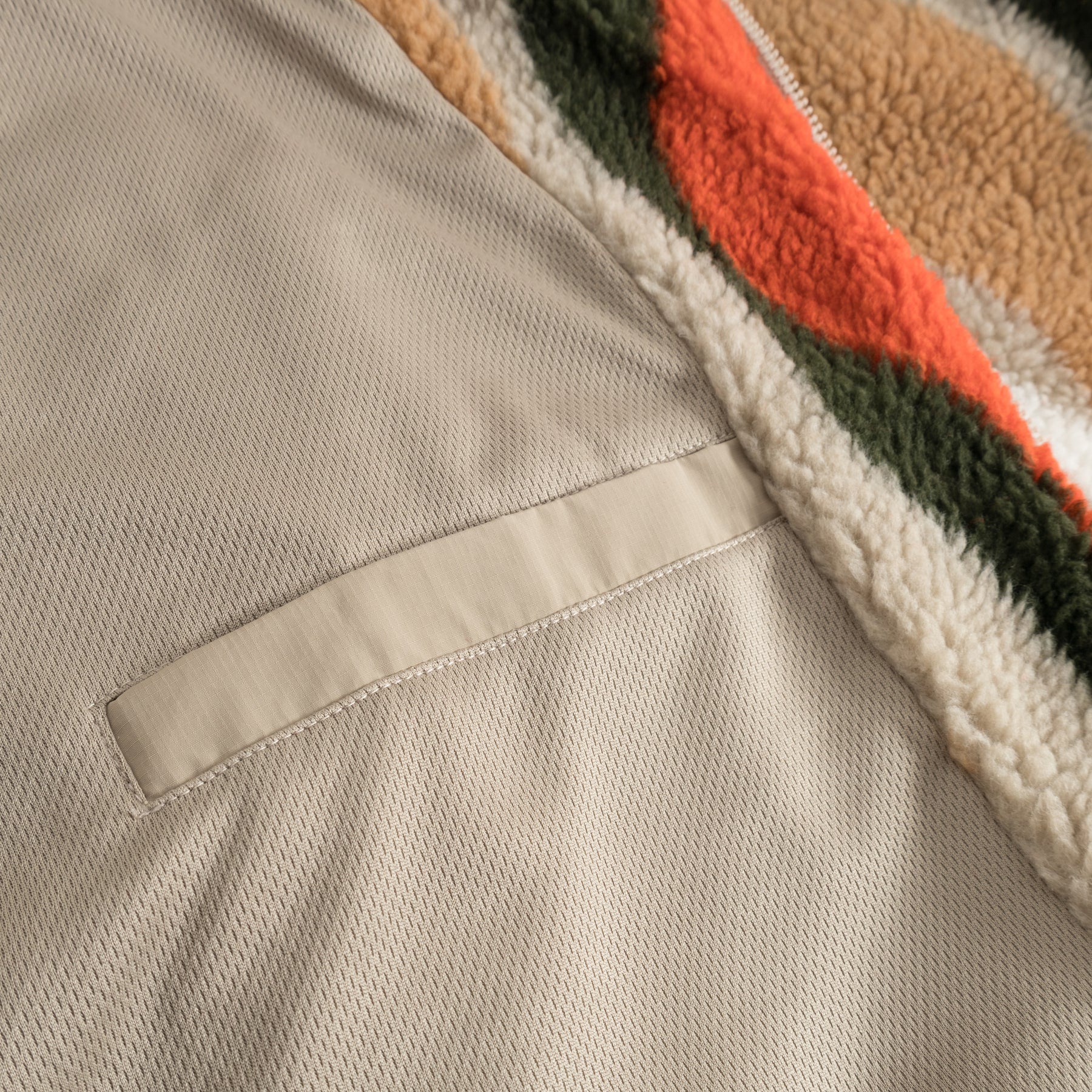 Detailaufnahme der beige getragenen Cropped Teddy Fleecejacke 'Carey' mit farbigem Teddy-Fleece-Muster