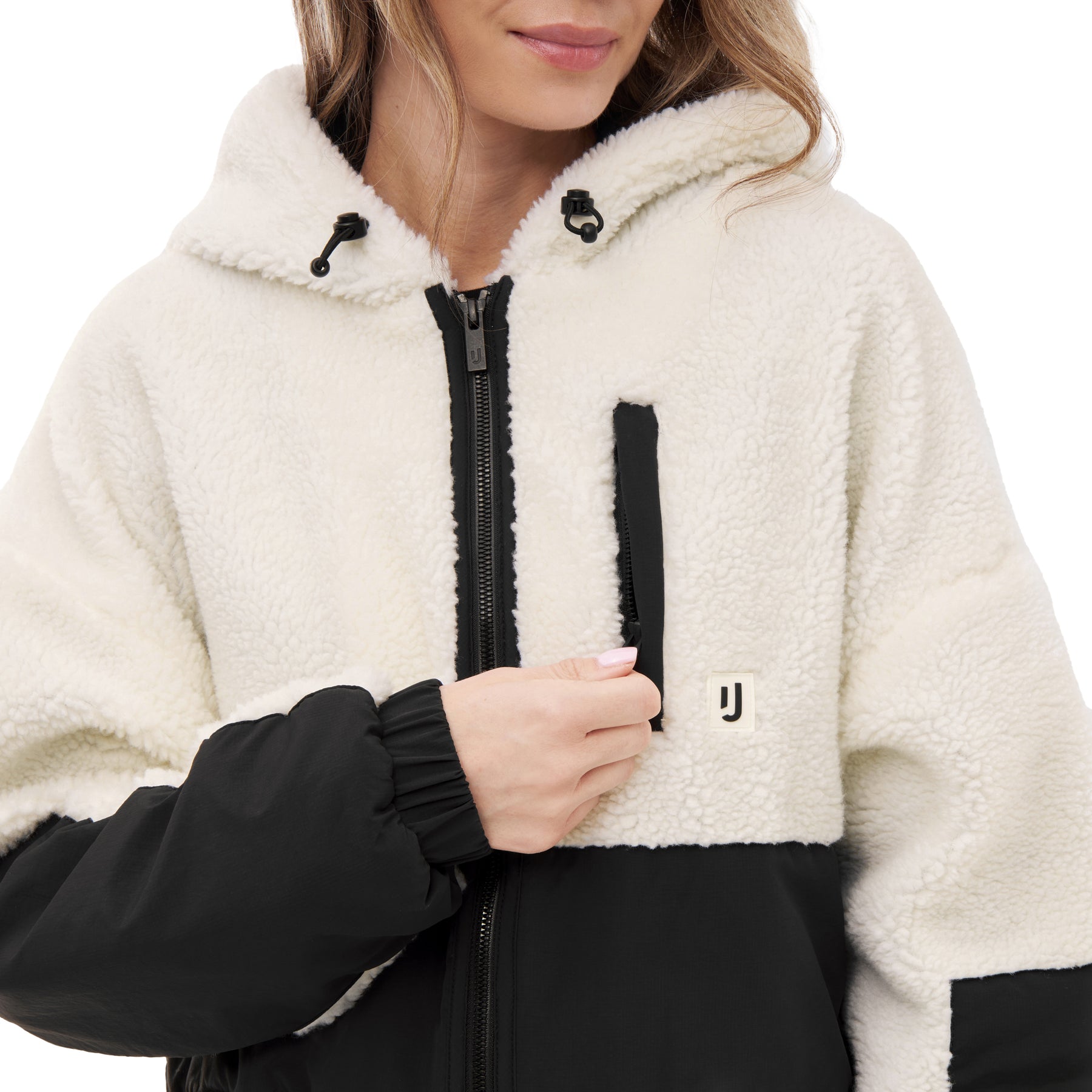 Frau trägt weiße und schwarze Cropped Teddy Fleecejacke 'Carey' mit Kapuze und Reißverschluss