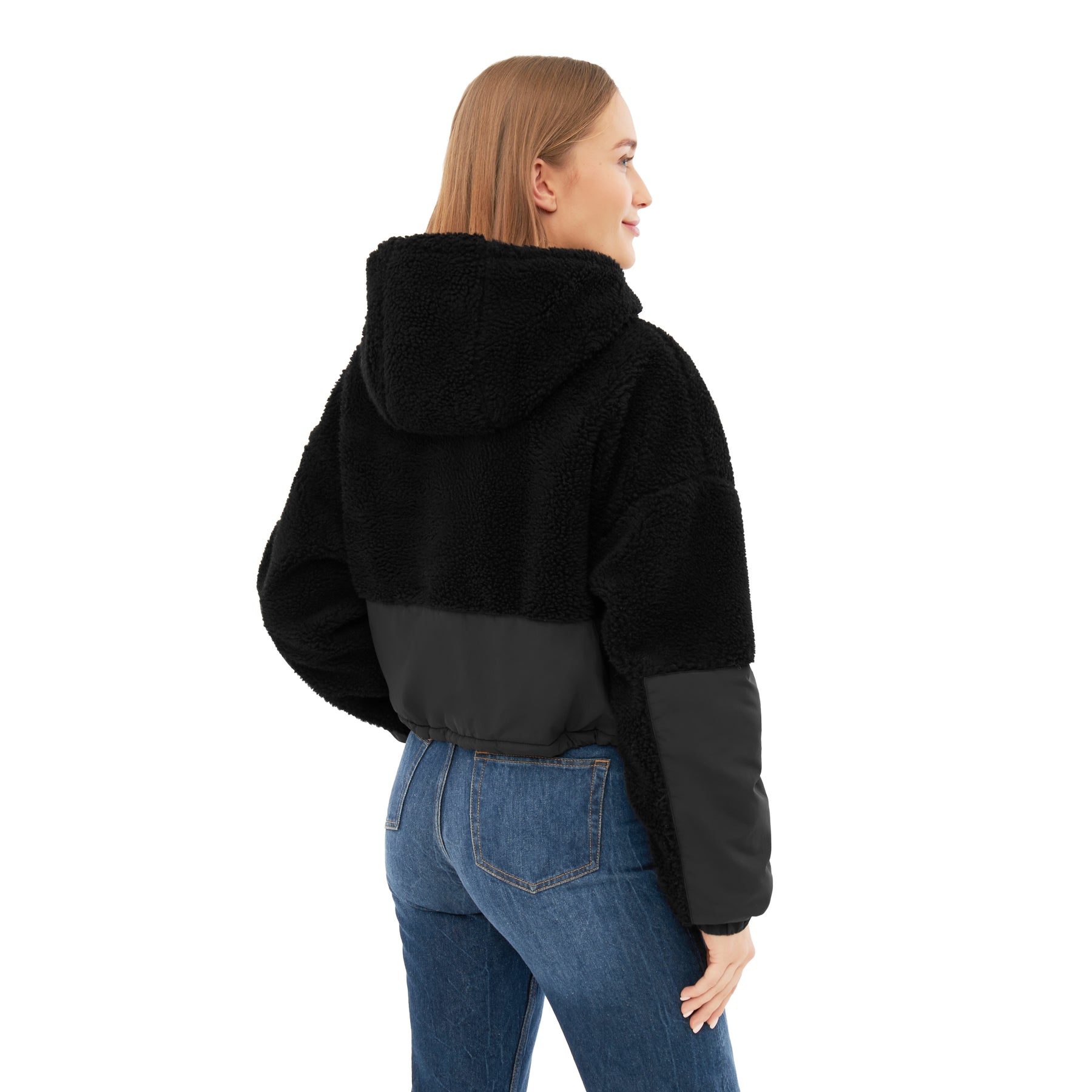 Rückansicht einer Frau in schwarzer Cropped Teddy Fleecejacke 'Carey' mit Kapuze und blauer Jeans