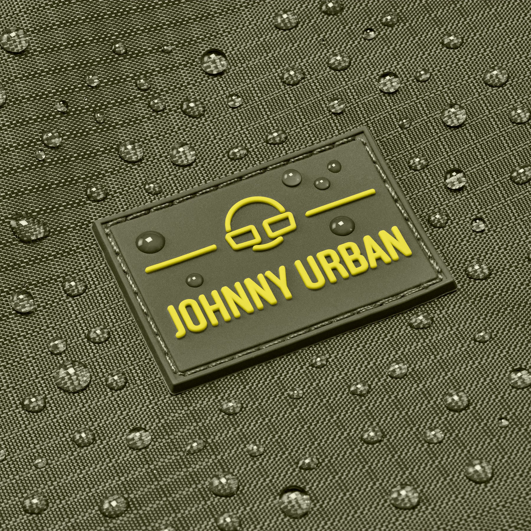 Nahaufnahme des wasserabweisenden Materials einer Johnny Urban Duffle Bag ‚Shawn Large‘ mit Logo und Wassertropfen