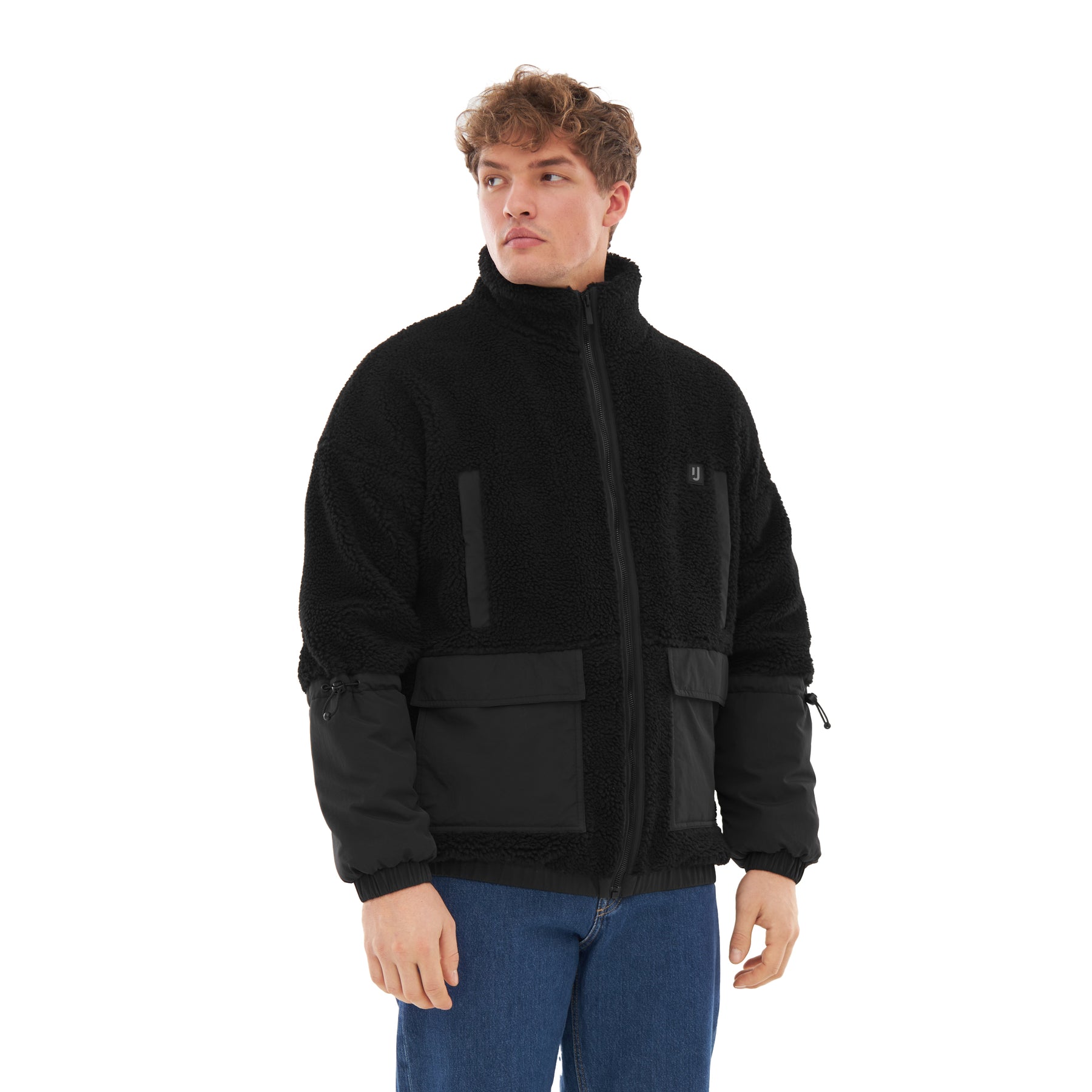 Mann trägt schwarze Johnny Urban Teddy Fleecejacke 'Carson' mit grober Textur, Reißverschluss und Stoffeinsätzen an Ärmeln und Taschen