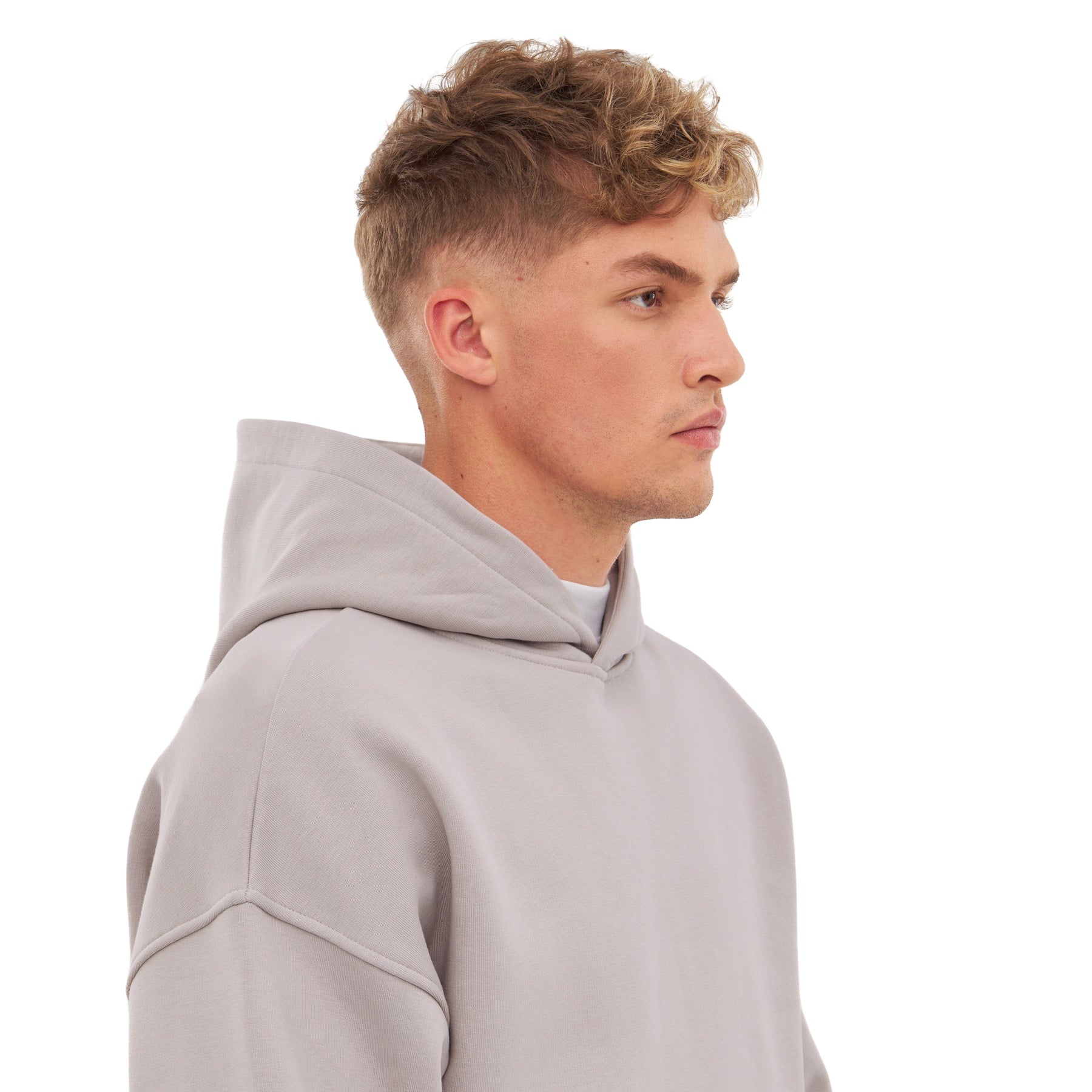 Mann trägt hellgrauen oversized Hoodie 'Cody' mit Kapuze, seitliche Ansicht