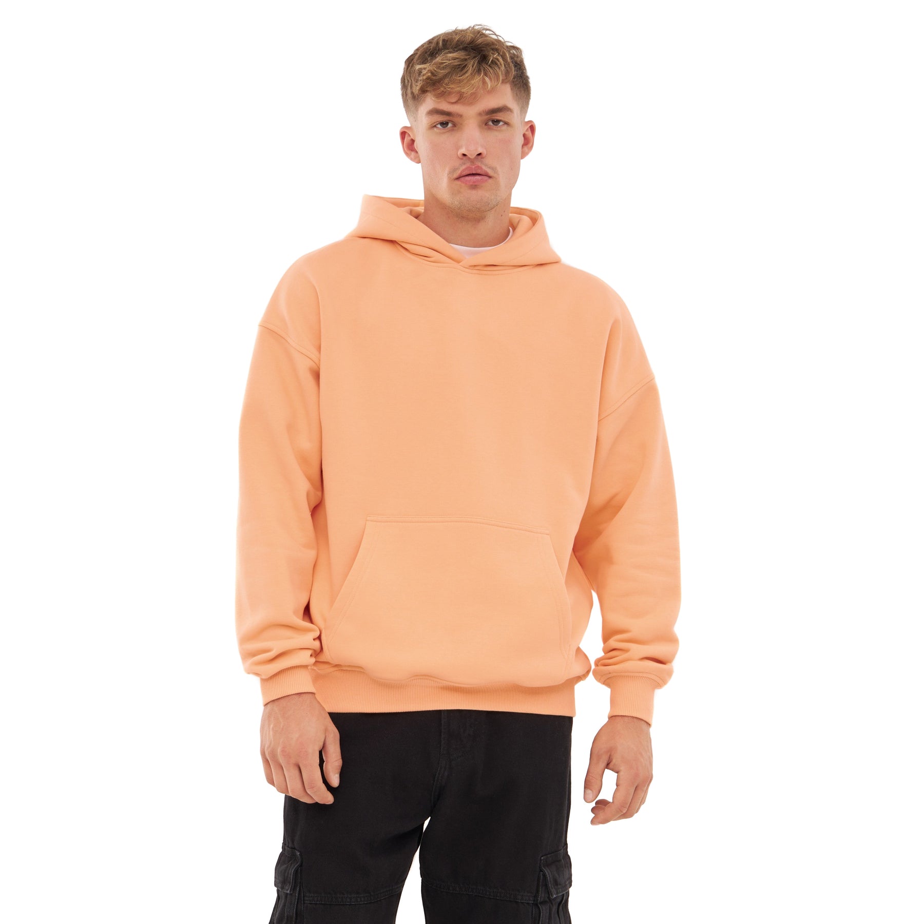 Mann trägt oversized Hoodie 'Cody' in Pfirsich mit Kapuze und Kängurutasche
