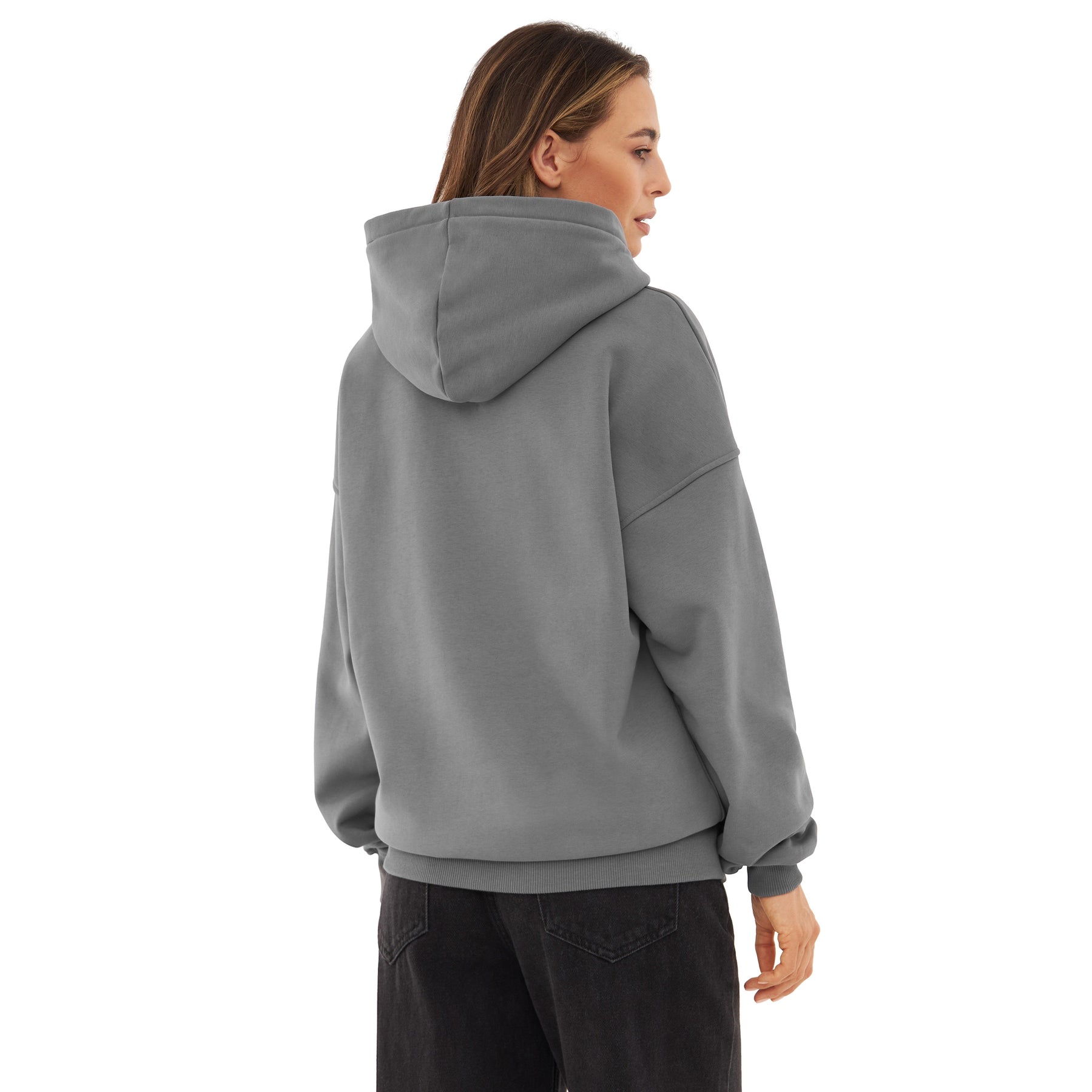 Rückansicht einer Frau mit oversized Hoodie 'Cody' in Grau, kombiniert mit schwarzen Hosen