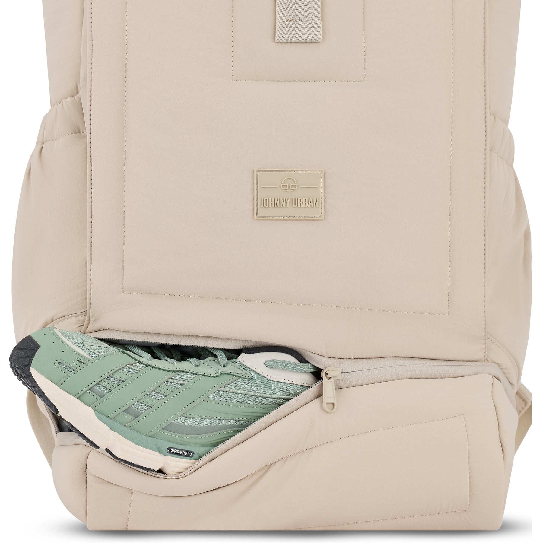 Sandfarbener Rolltop-Rucksack 'Kyle' von Johnny Urban mit geöffnetem Reißverschlussfach, darin grün-weißer Sportschuh