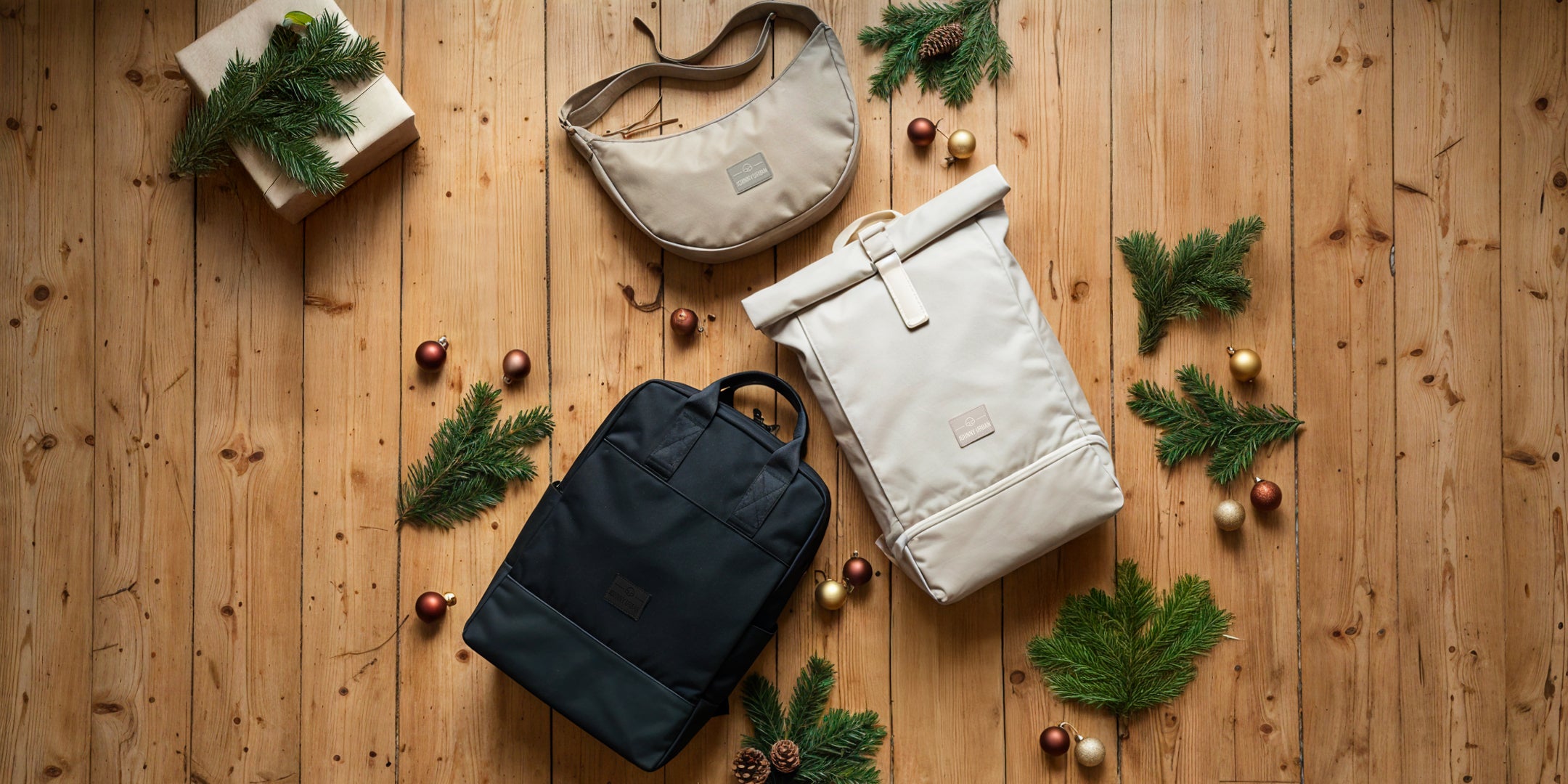 Johnny Urban Taschen und Rucksäcke auf einem Laminatboden mit Tannenzweigen und Weihnachtsdeko.