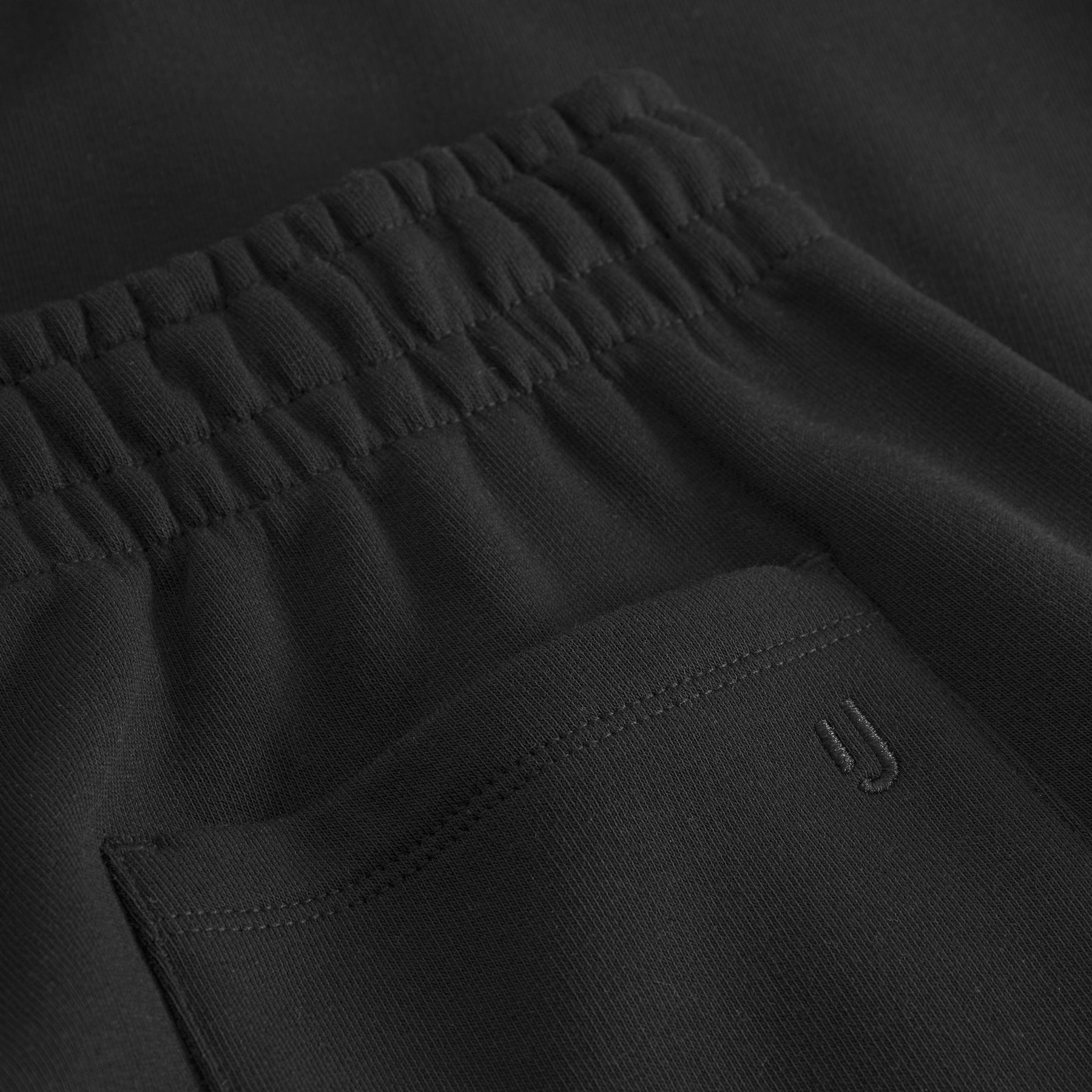 Schwarze Jogginghose 'Owen' mit elastischem Bund und eingesticktem 'JU'-Logo auf der Tasche