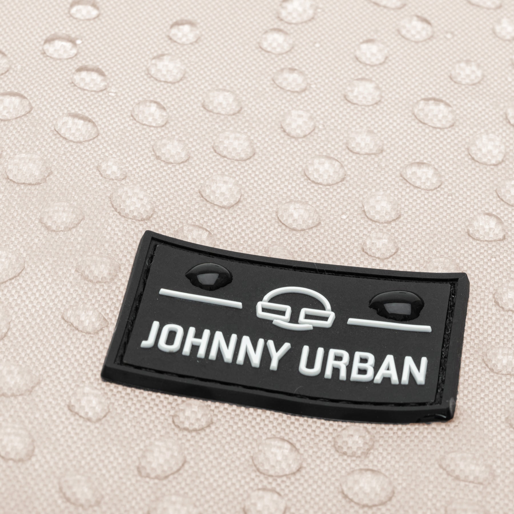 Nahaufnahme des wasserabweisenden beige gefärbten Stoffes des Turnbeutels 'Blake' mit schwarzem Johnny Urban Logo