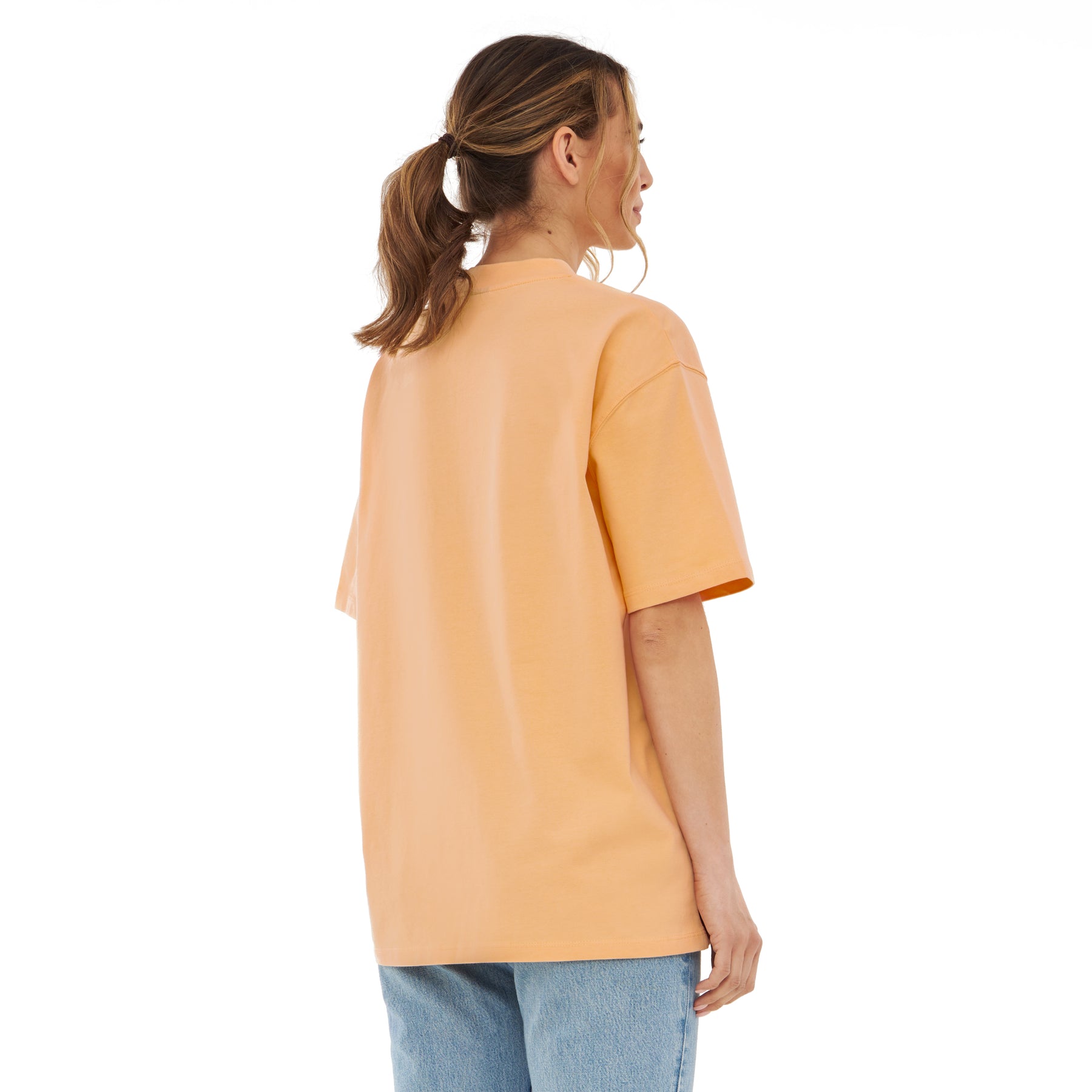 Damen trägt oversized T-Shirt 'Sammy' in Pfirsichfarbe mit kurzen Ärmeln, Rückansicht