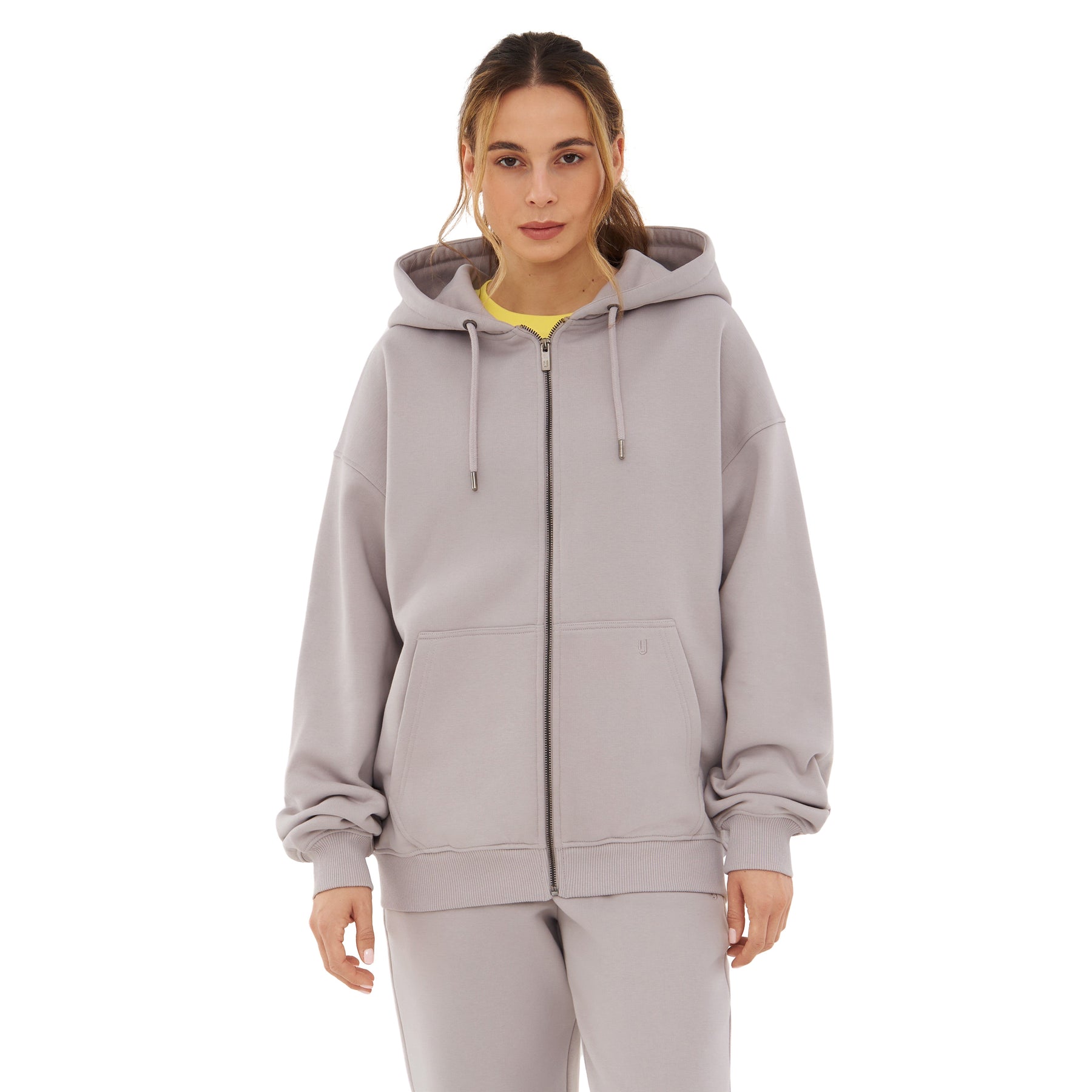 Frau trägt oversized Zip Hoodie ‚Caleb‘ in Grau mit Kapuze und Kängurutaschen