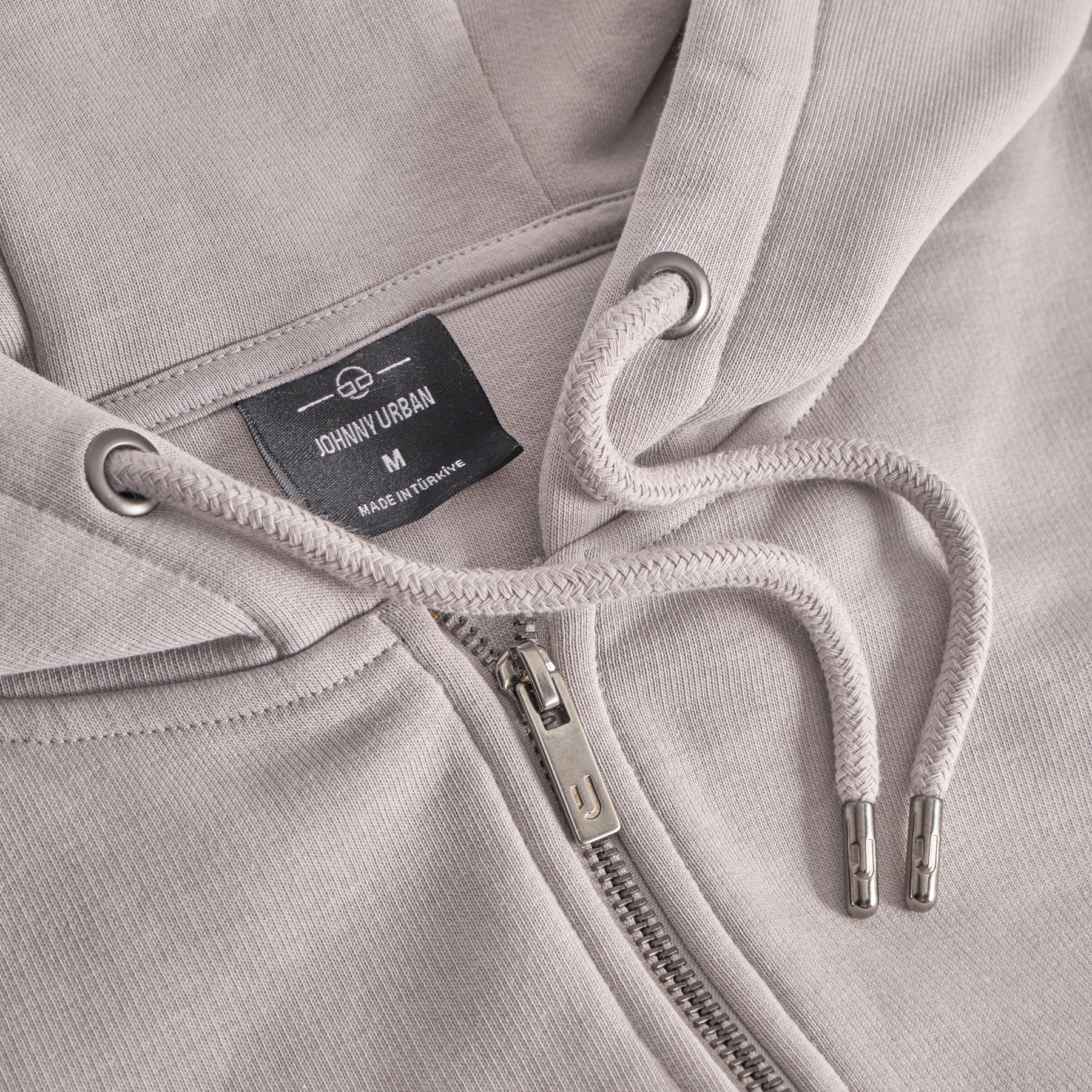 Detailansicht des Kapuzenzugs und Reißverschlusses der oversized Zip Hoodie 'Caleb' in Beige von Johnny Urban
