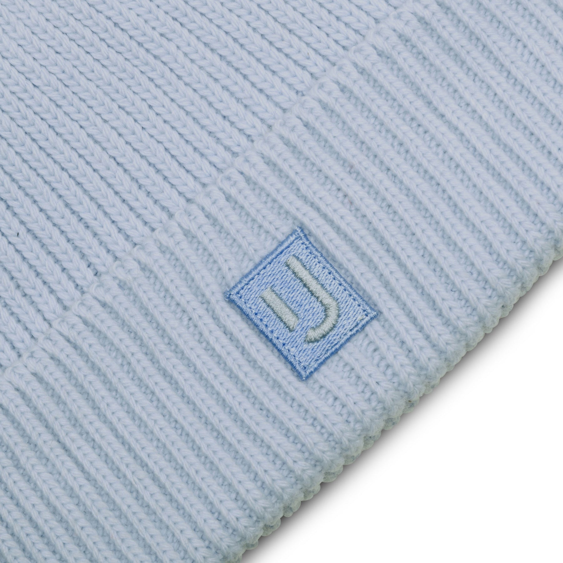 Hellblaue gerippte Strickmütze „Billie“ mit einem kleinen quadratischen Patch mit ‚JU‘-Logo