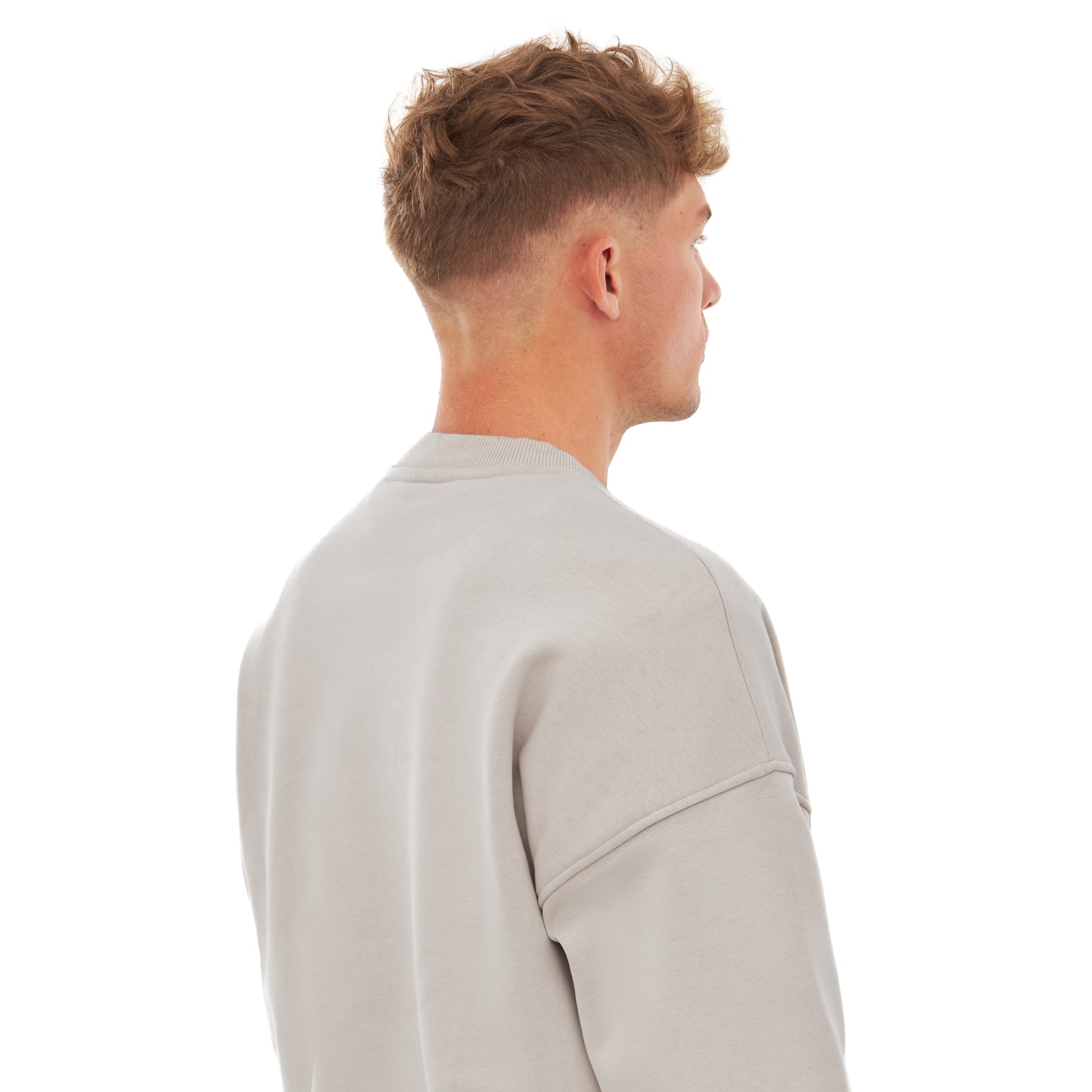 Mann von hinten mit kurzem hellbraunem Haar trägt beigen oversized Crewneck Pullover 'Carter' mit Raglanärmeln