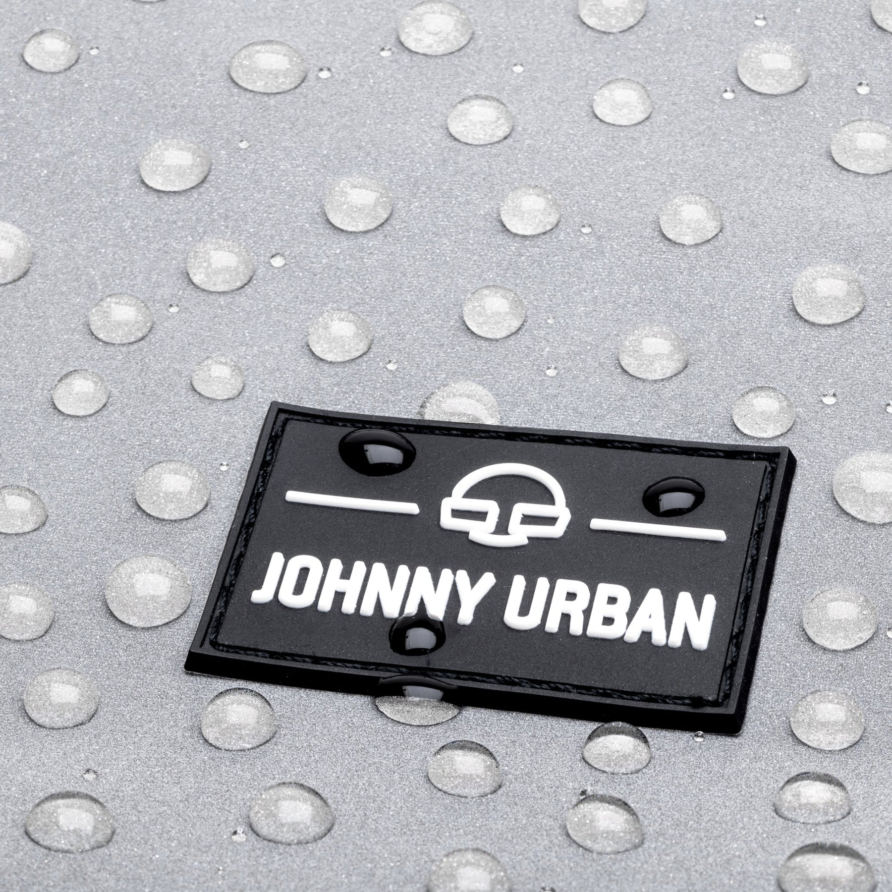 Johnny Urban Logo auf reflektierendem, wasserabweisendem Material mit Wassertropfen
