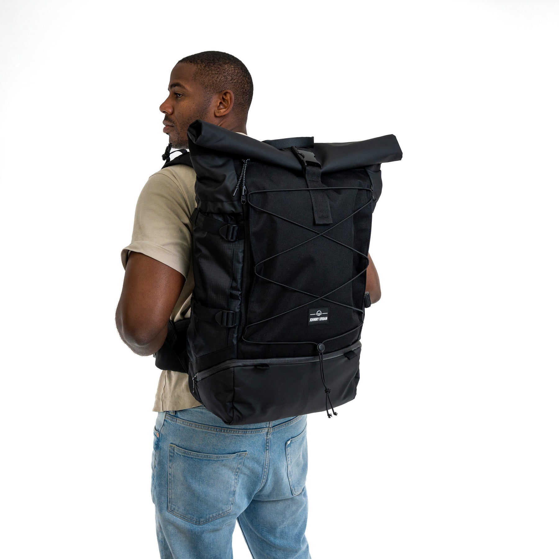Mann mit beigem T-Shirt trägt schwarzen Reiserucksack 'Allen XL Travel' von Johnny Urban mit Rollverschluss und Fronttasche