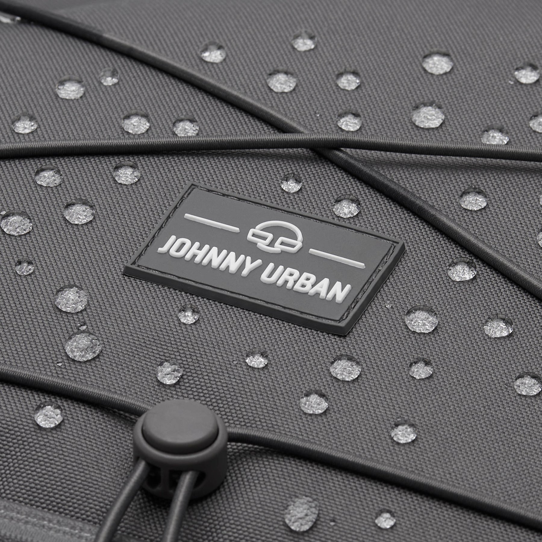 Nahaufnahme des grauen Johnny Urban Reiserucksacks 'Allen XL Travel' mit Wassertröpfchen auf dem Material