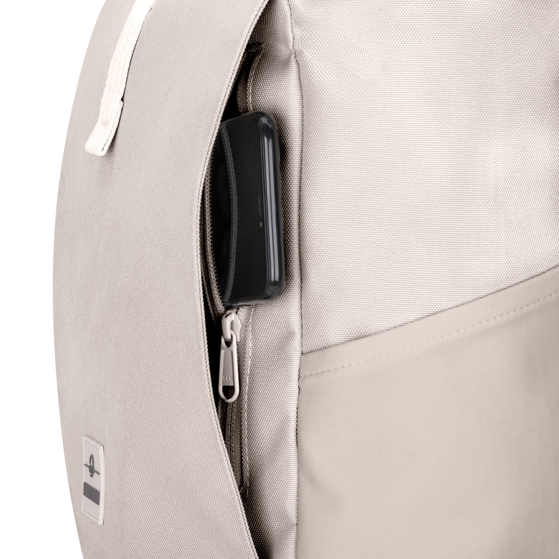 Rolltop Rucksack Allen Medium in heller Farbe mit geöffnetem seitlichem Reißverschlussfach und sichtbarem schwarzen Gegenstand