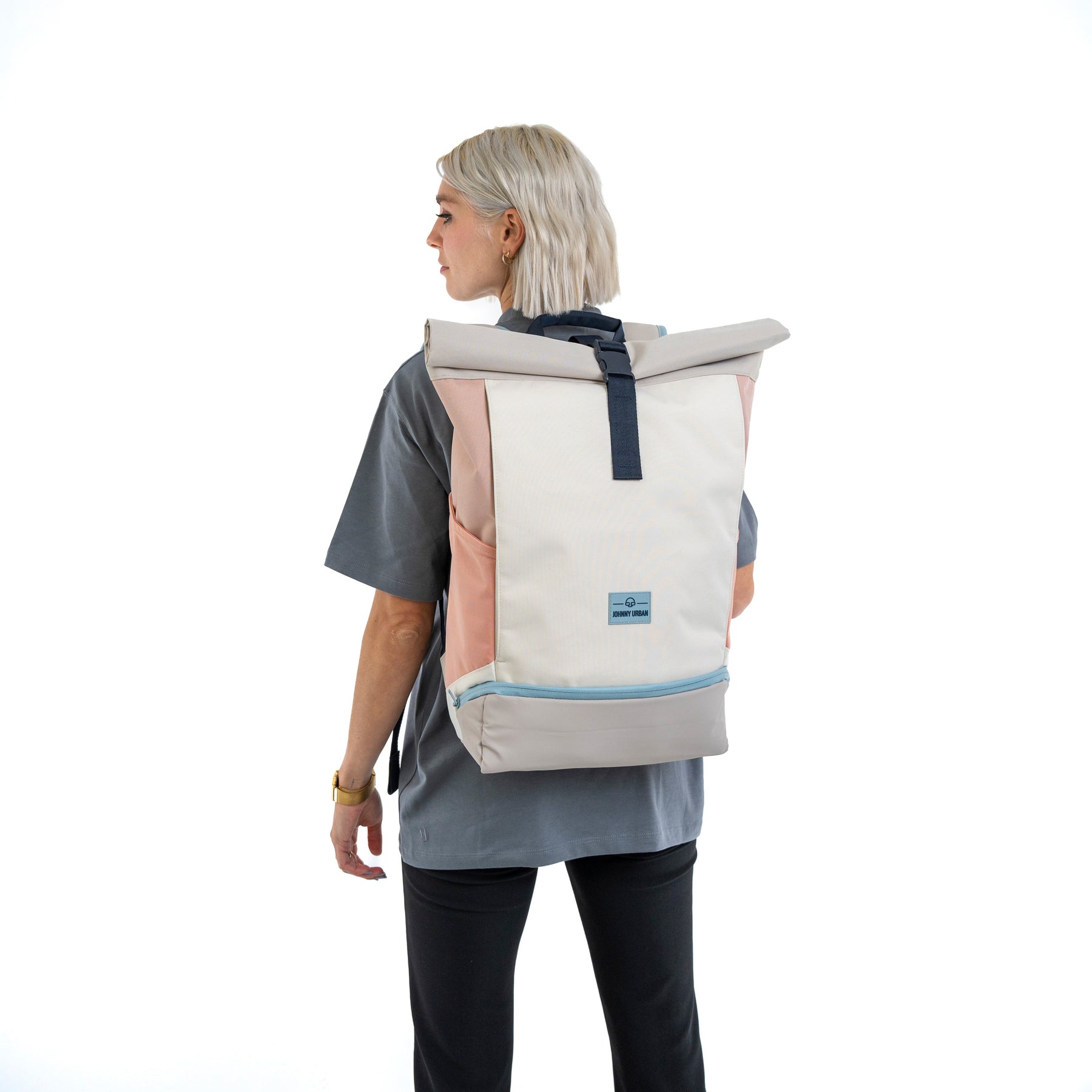 Dame mit Johnny Urban Rolltop Rucksack Allen Large in Sand Rose, seitlich stehend mit grauem Shirt