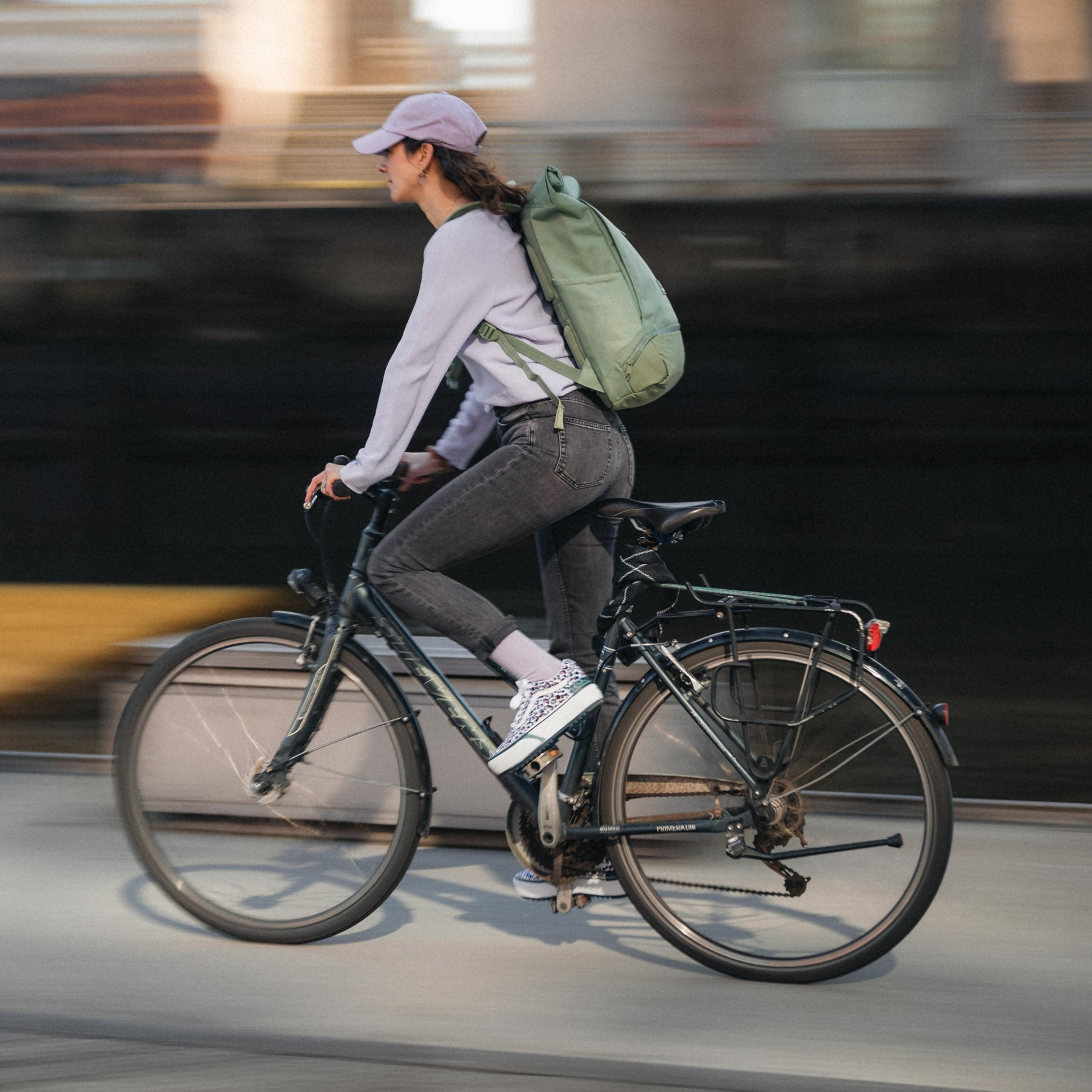 Frau fährt Fahrrad mit sage-grünem Rolltop-Rucksack Allen Large von Johnny Urban