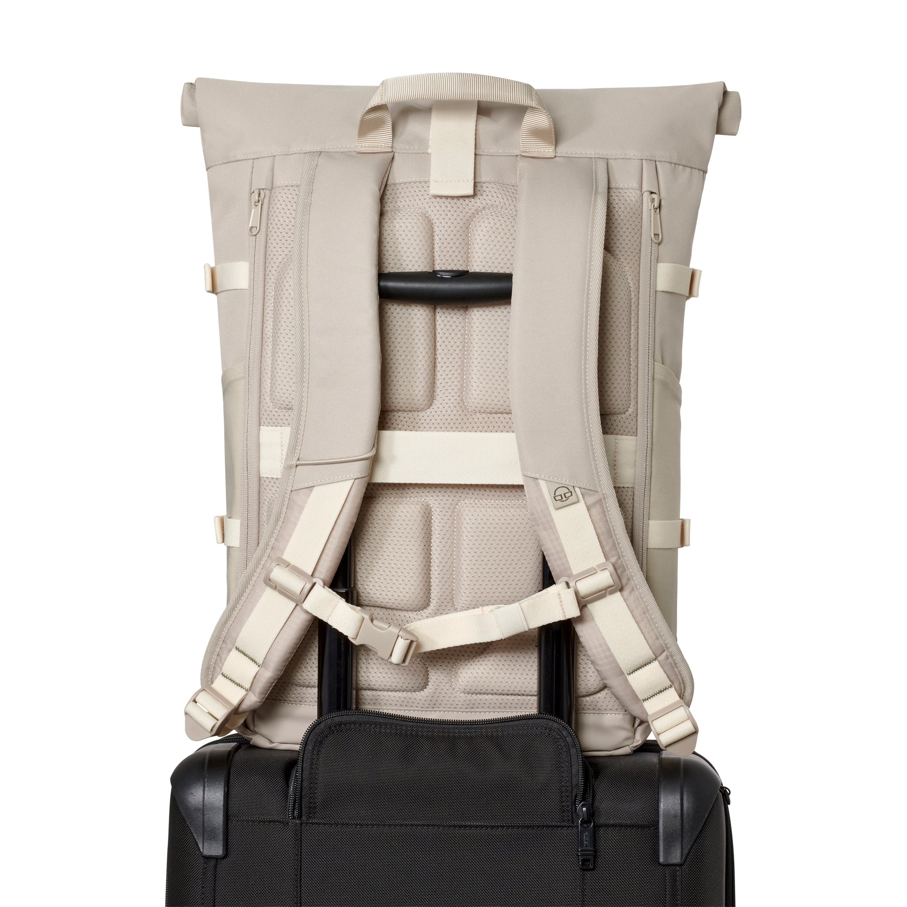 Sandfarbener Rolltop Rucksack 'Allen Large Move' mit gepolsterten Schulterriemen an einem schwarzen Koffer