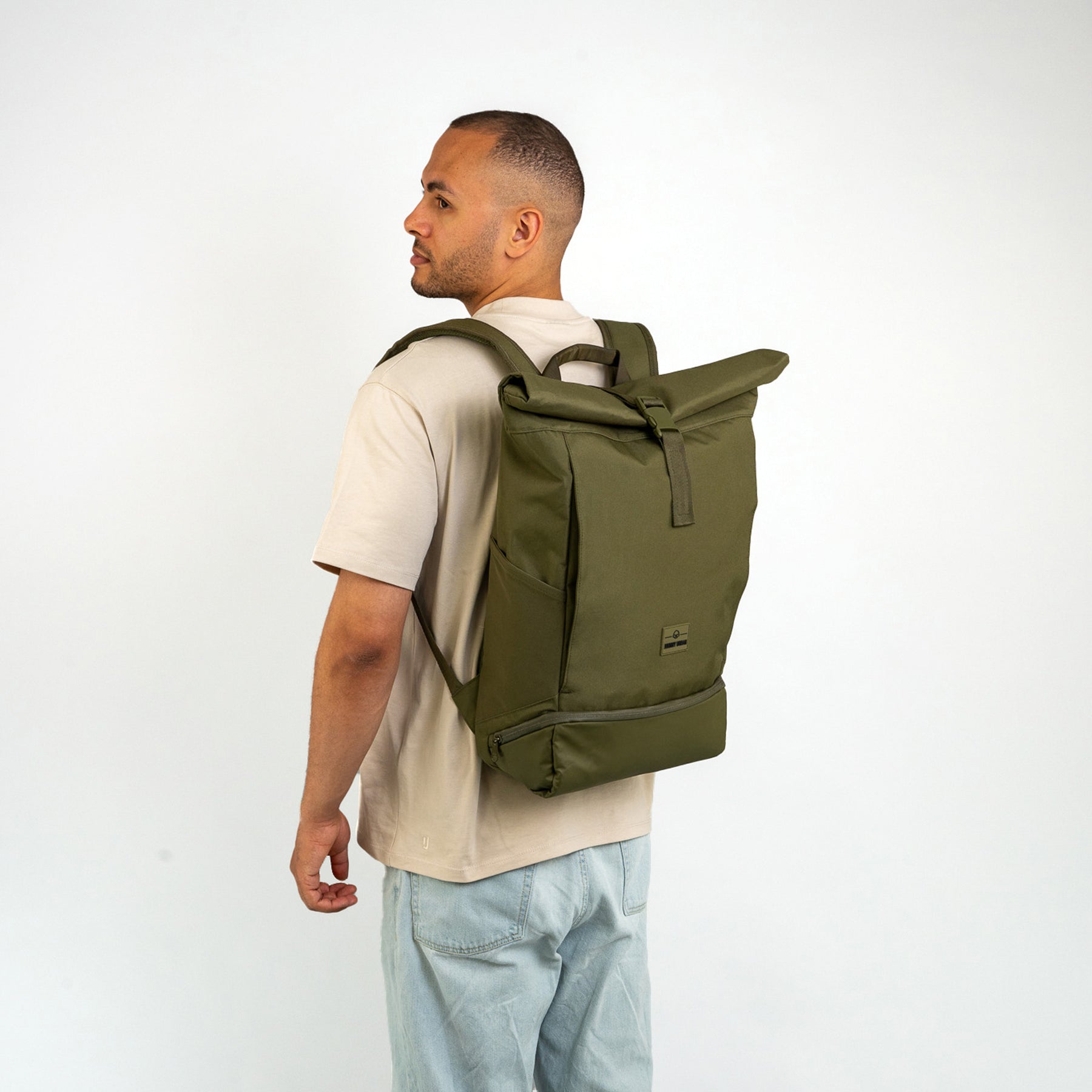 Mann trägt olivgrünen Rolltop Rucksack 'Allen Large' von Johnny Urban