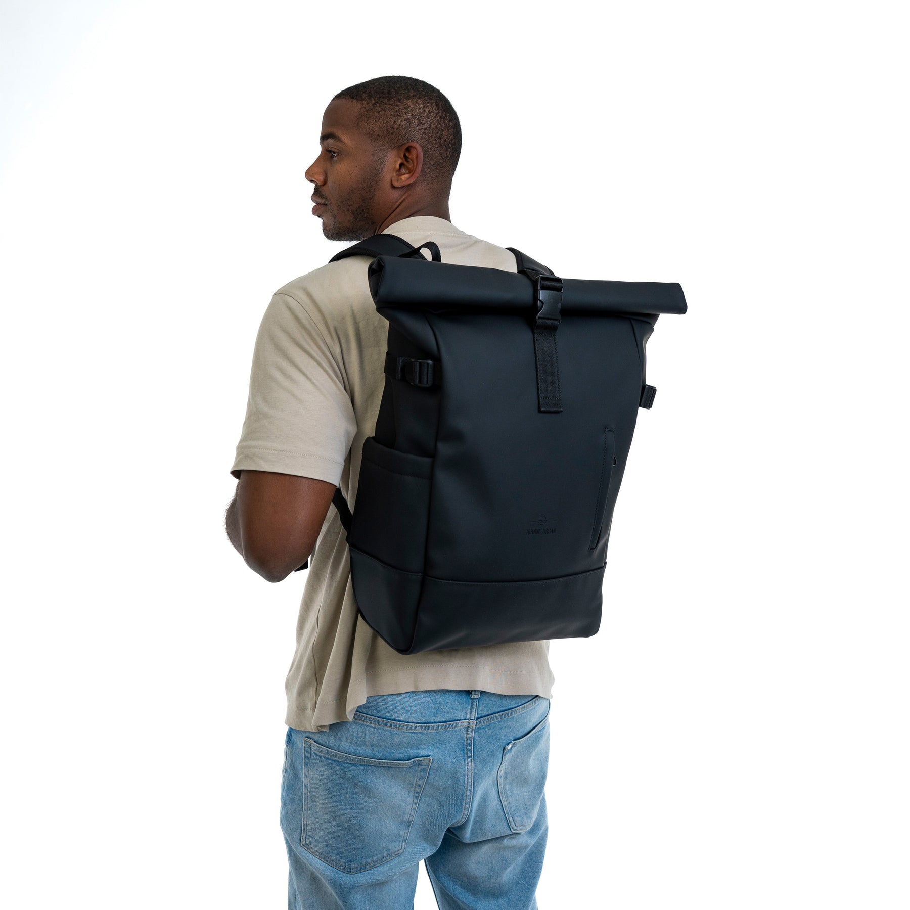 Mann trägt schwarzen Rolltop Rucksack 'Harvey Large' aus robustem Material