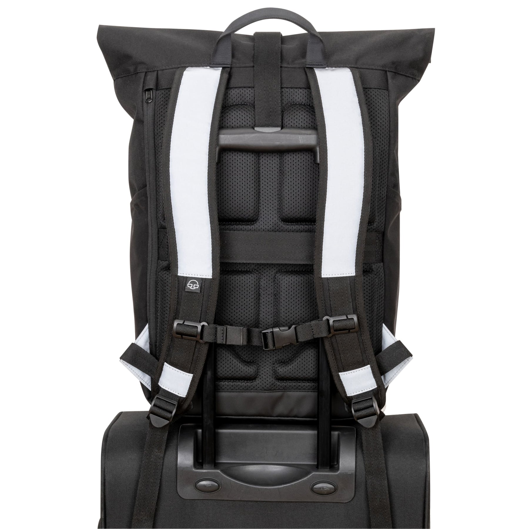 Rückansicht des Rolltop Rucksacks 'Allen Large' mit reflektierenden schwarzen und weißen gepolsterten Schultergurten auf einem Reisekoffer