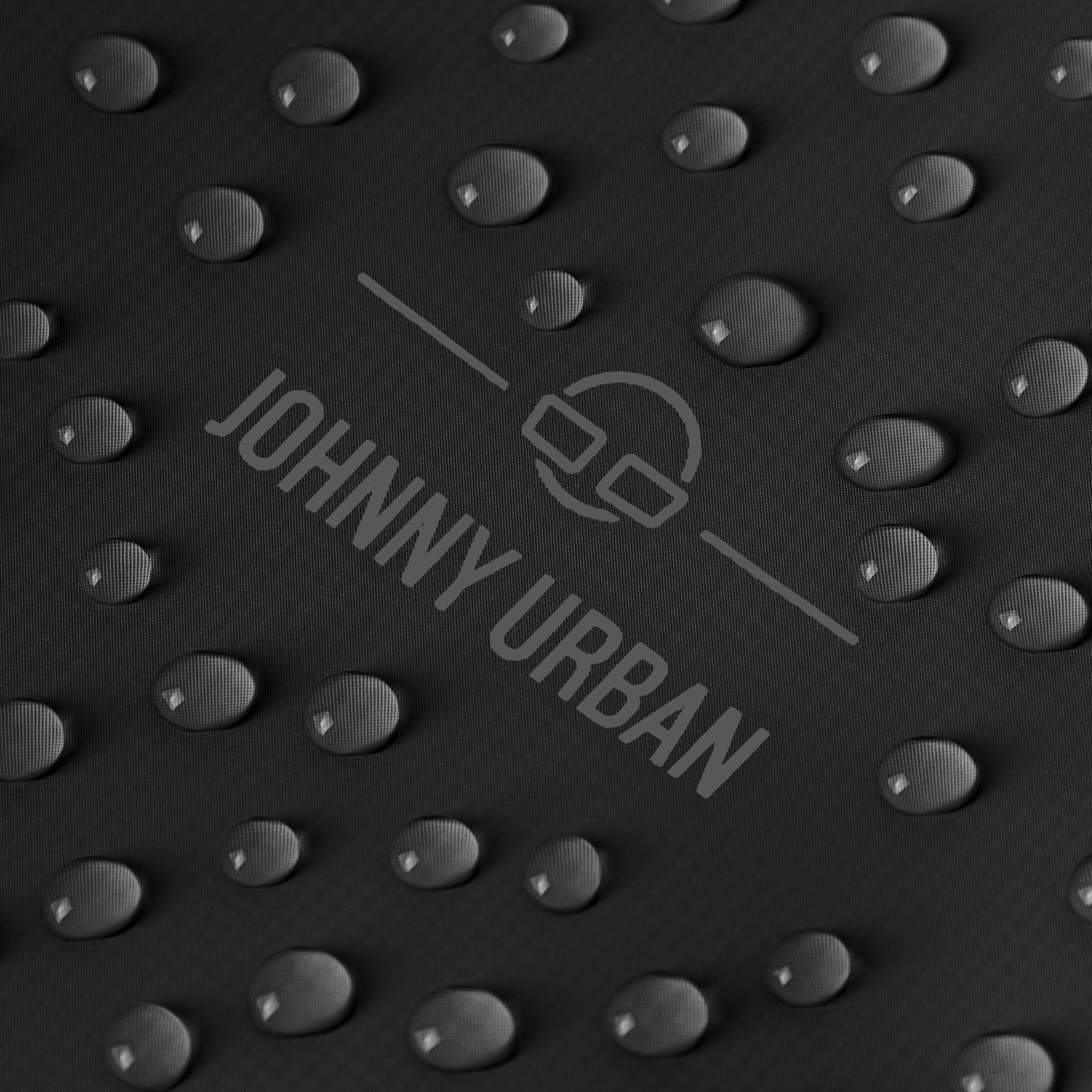 Nahaufnahme von Wassertröpfchen auf dem schwarzen Material des rolltop Rucksacks 'Conor' von Johnny Urban