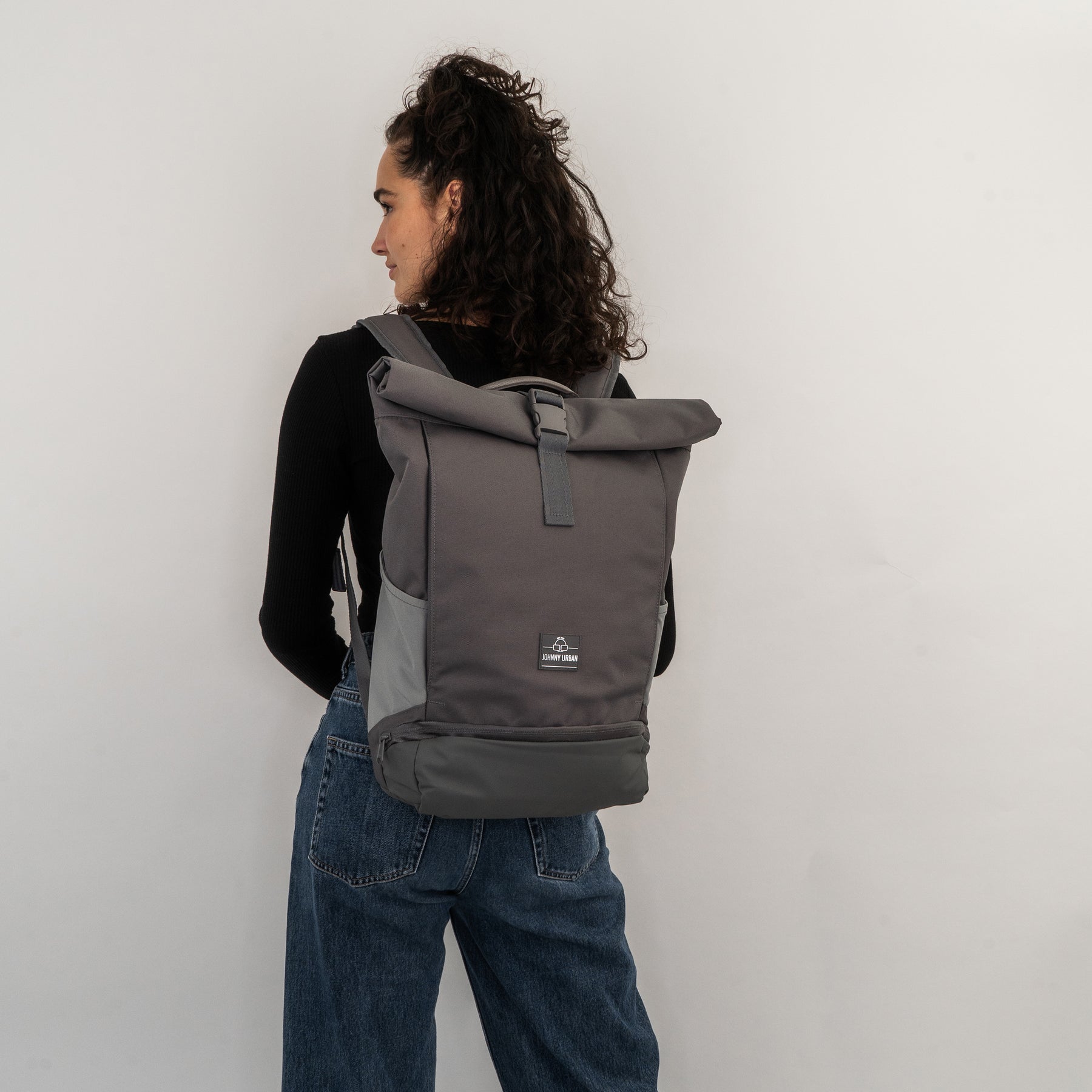 Frau von hinten mit dunkelgrauem Rolltop Rucksack Allen Medium von Johnny Urban