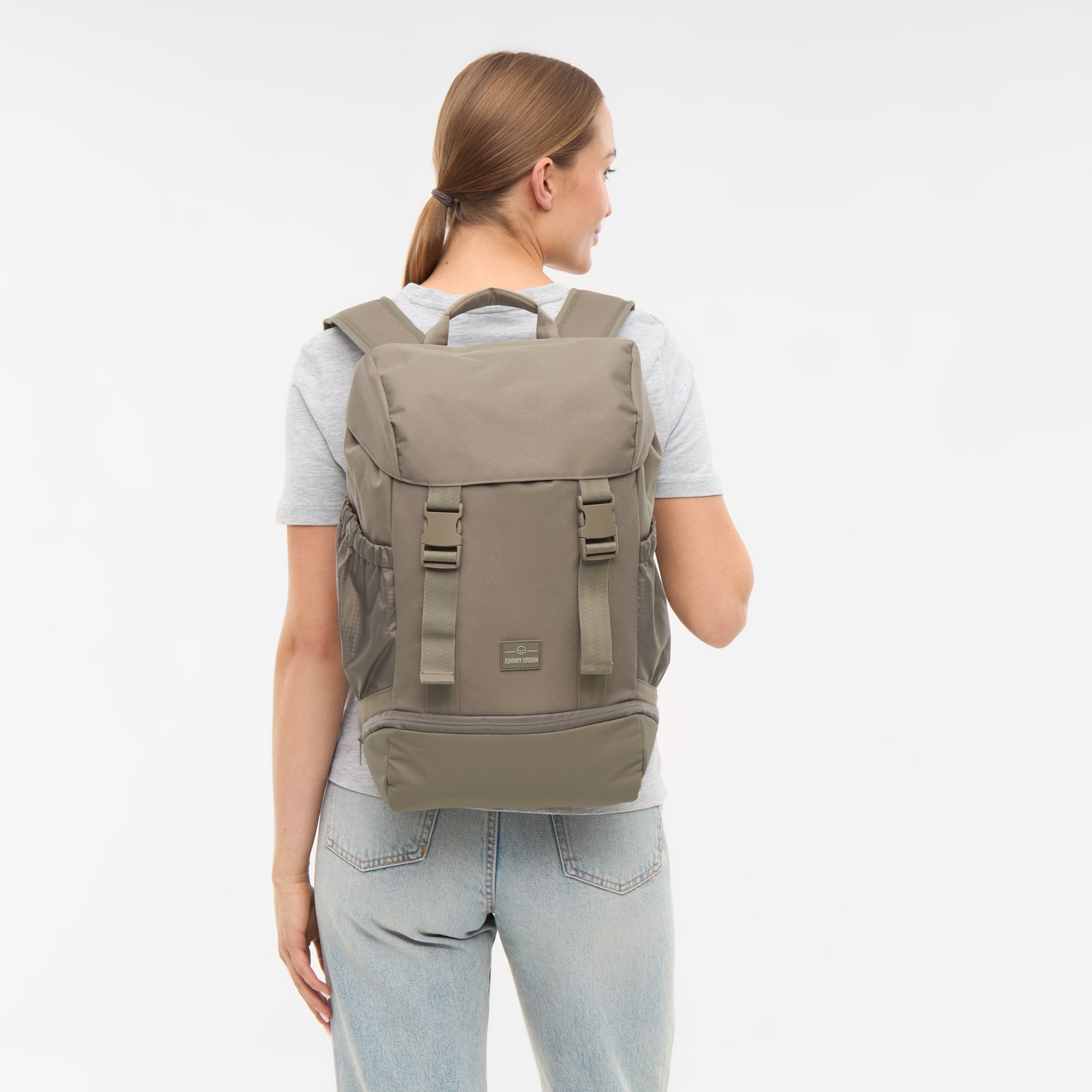 Frau trägt Rucksack 'Nico' in desert grey, Rückansicht, mit verstellbaren Schulterriemen und seitlichen Taschen