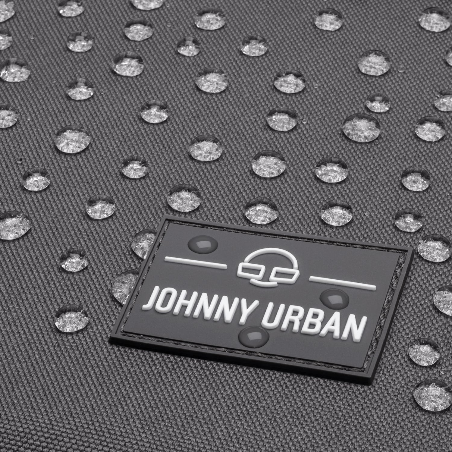 Wasserdichte Oberfläche mit Wassertropfen auf Johnny Urban Logo am Rolltop Rucksack 'Robin Medium'