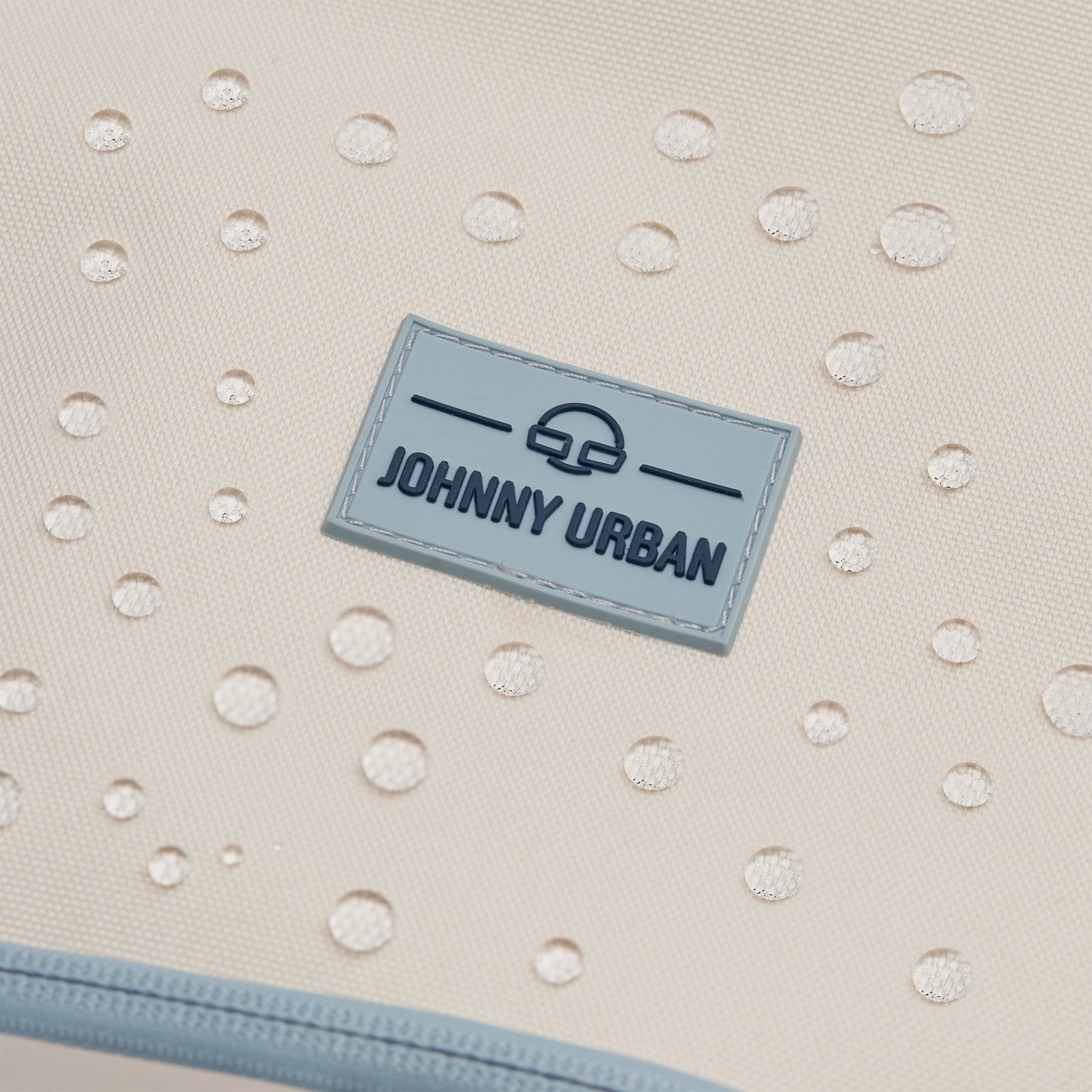 Beige wasserabweisendes Material mit Johnny Urban Logo und Wasserperlen