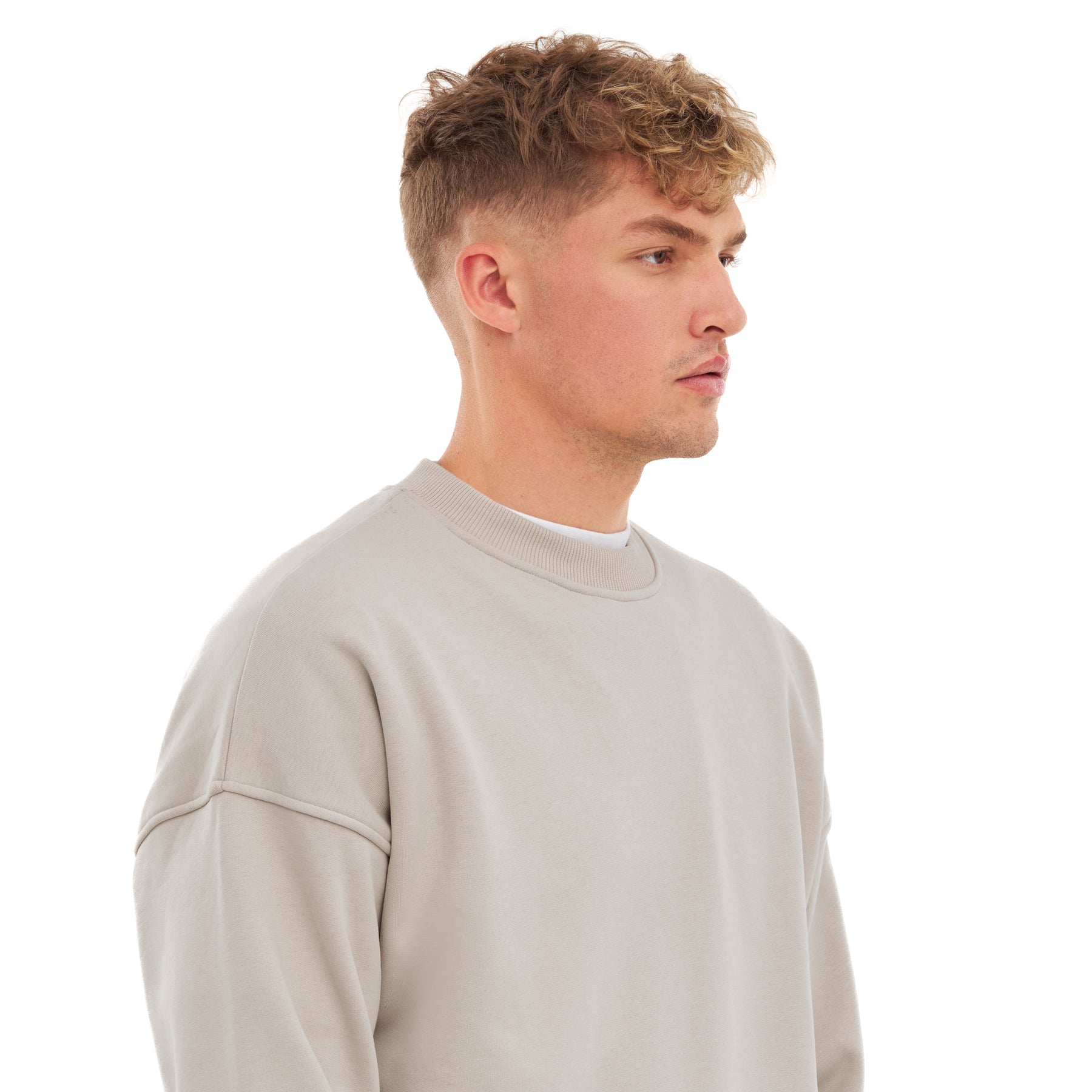 Mann im sandbeigen oversized Crewneck 'Carter' Pullover von Johnny Urban, Seitlich