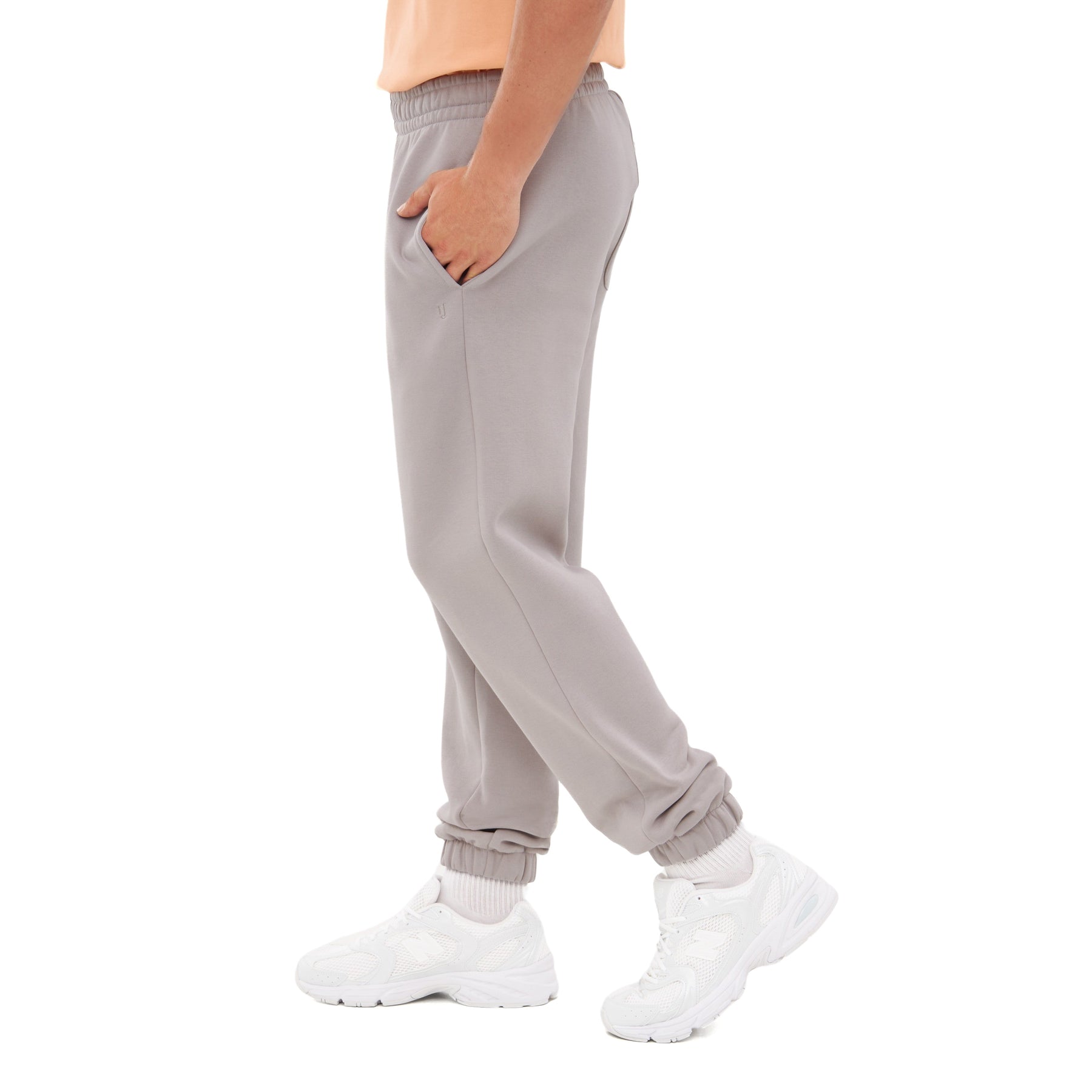 Seitliche Ansicht einer grauen Herren-Jogginghose 'Owen' mit elastischem Bund und Bündchen, getragen mit weißen Sportschuhen