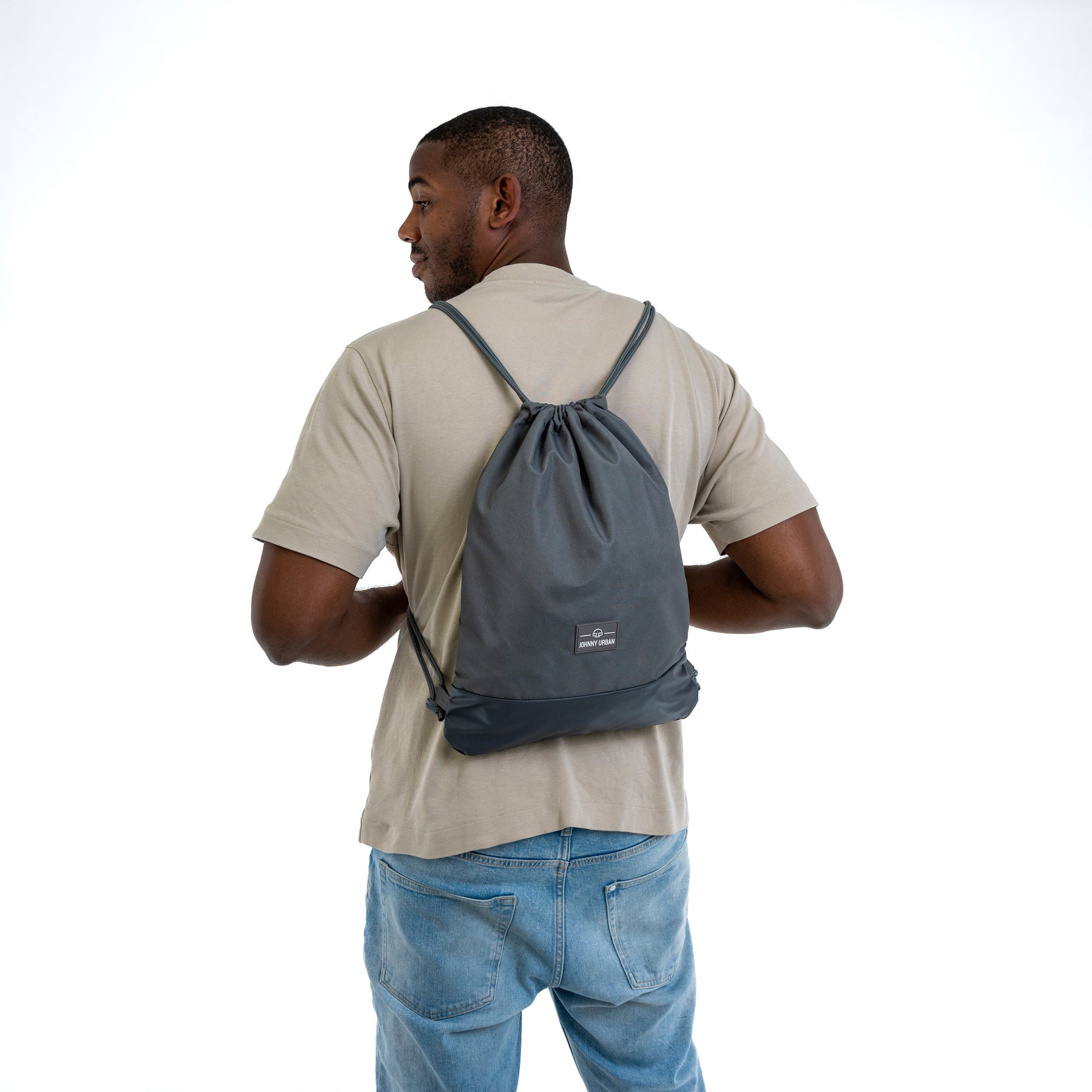Mann von hinten mit grauem Turnbeutel 'Blake' von Johnny Urban, beigem T-Shirt und blauer Jeans