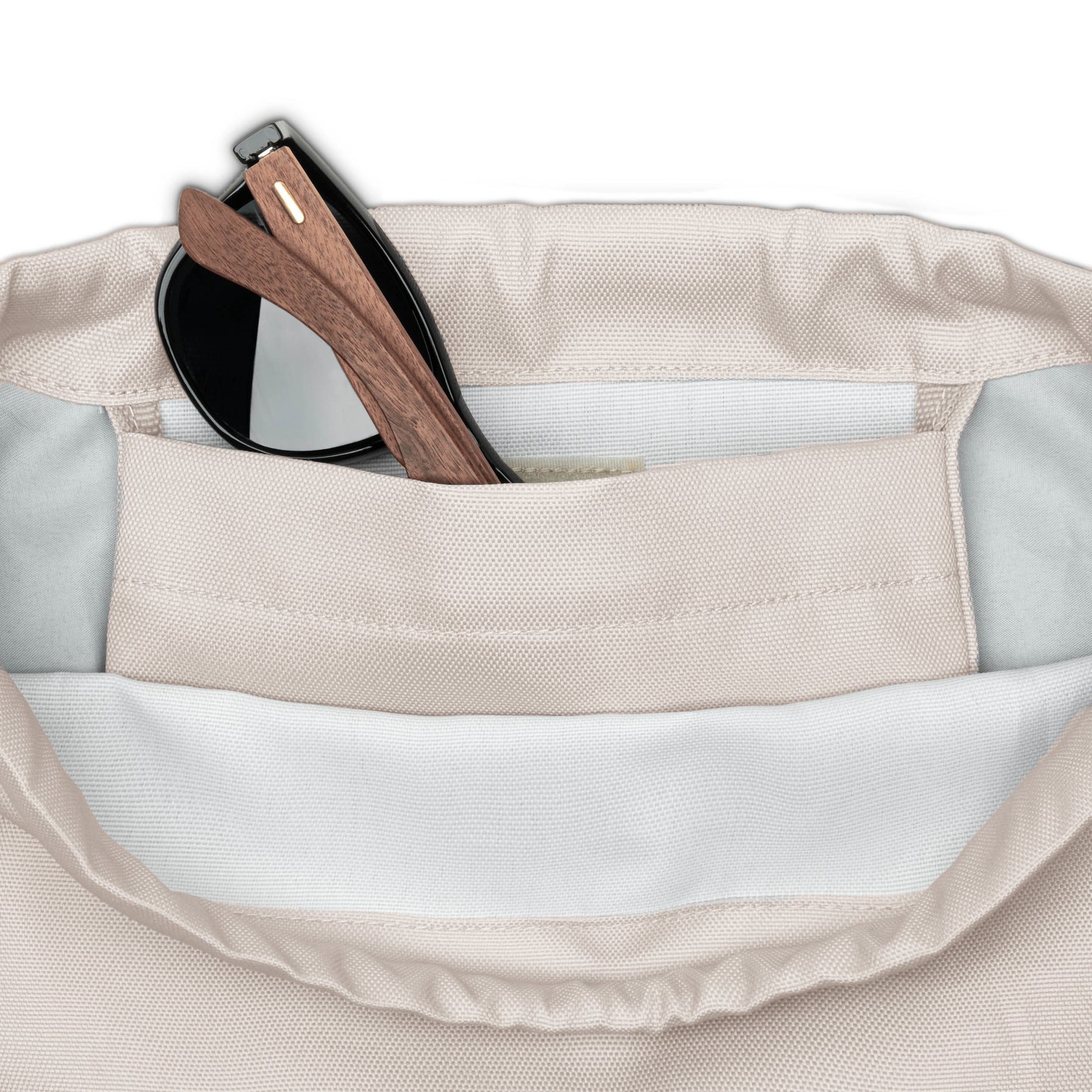 Beige Turnbeutel 'Blake' mit Innenfach, darin eine schwarze Sonnenbrille mit Holzgestell