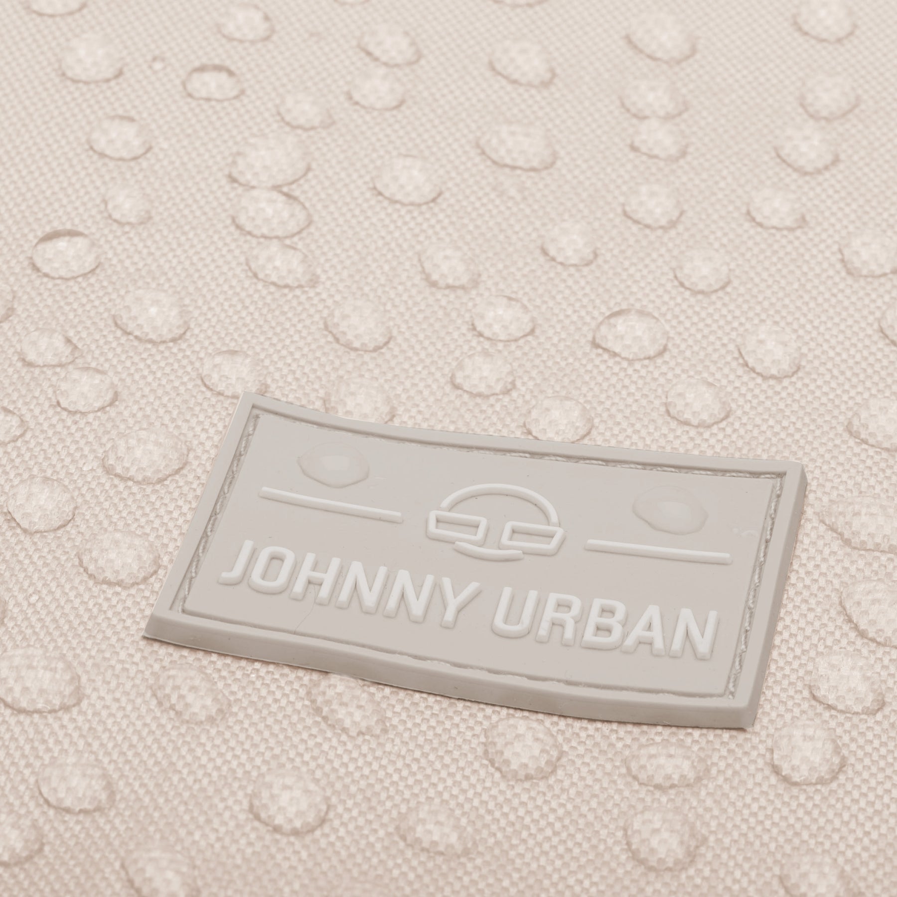 Nahaufnahme des wasserabweisenden beigen Turnbeutels 'Blake' mit geprägtem Johnny Urban Logo
