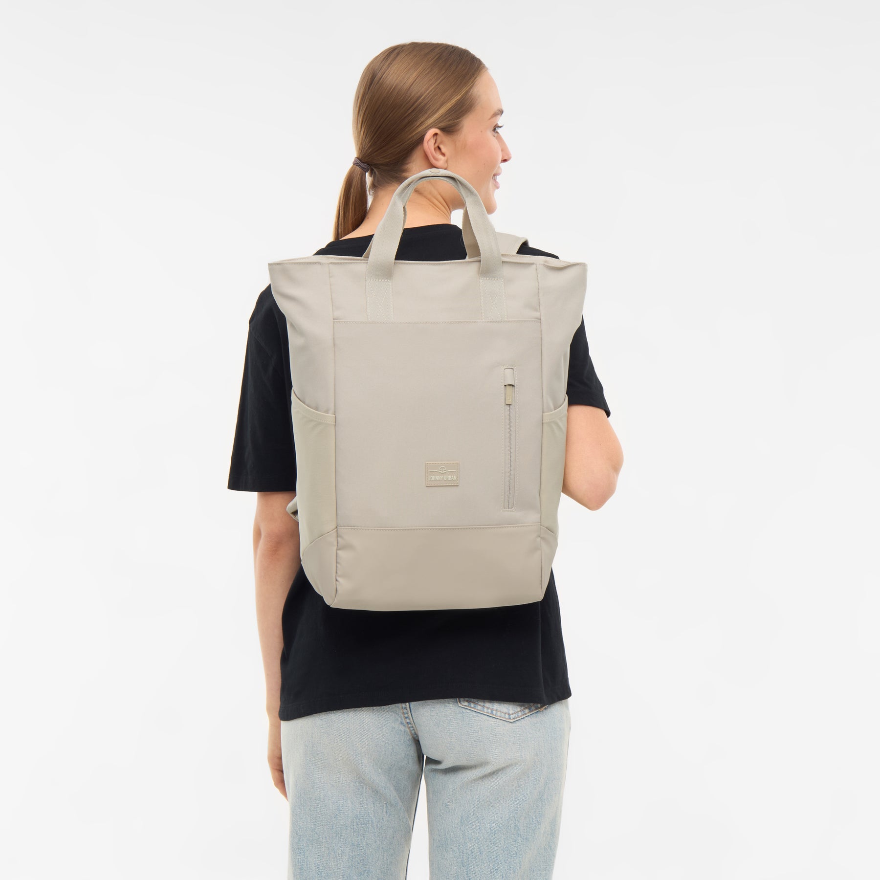 Frau trägt sandfarbene Wickeltasche 'Blair' von Johnny Urban im Rucksackstil