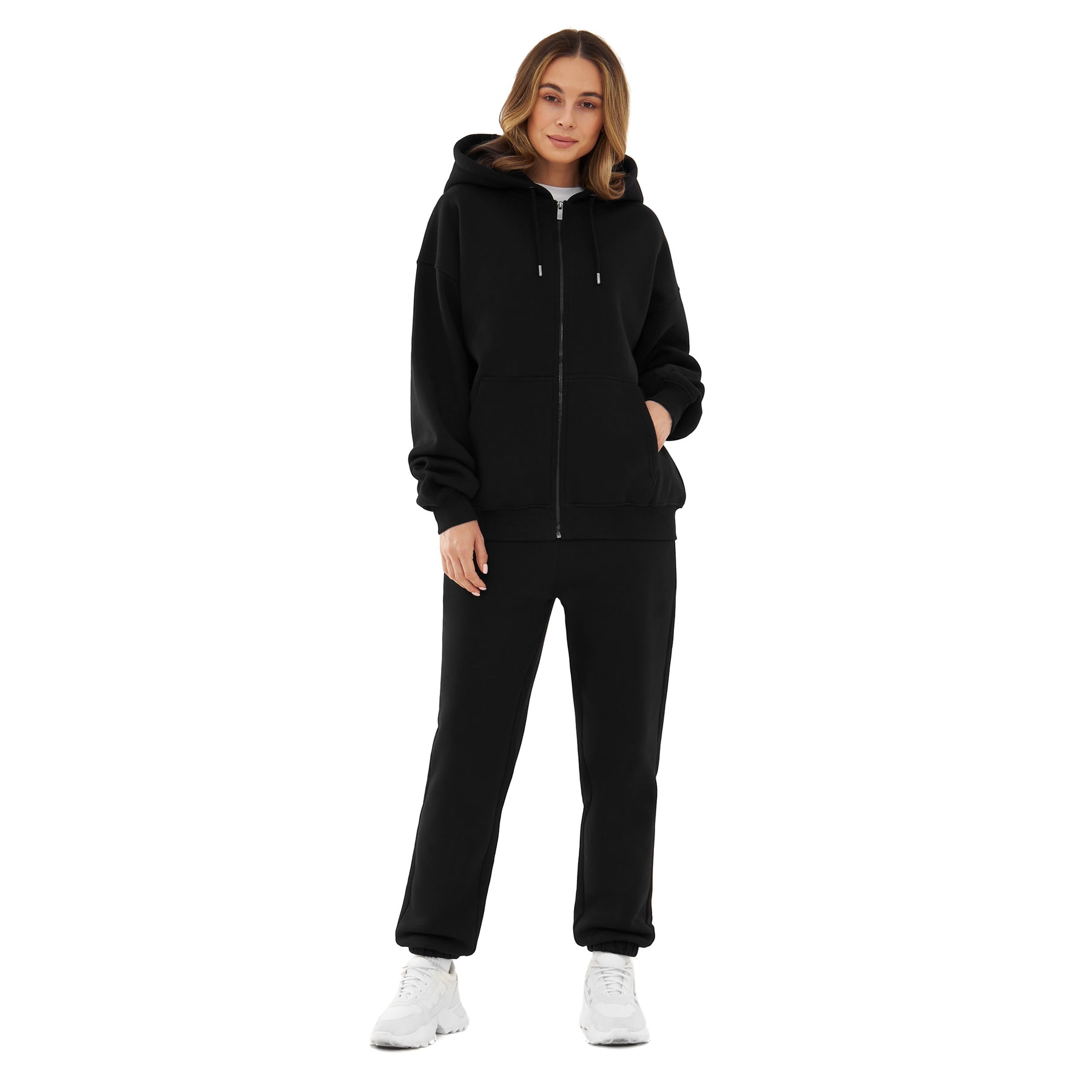 Frau trägt schwarzen oversized Zip-Hoodie 'Caleb' mit Kapuze und schwarzen Jogginghosen