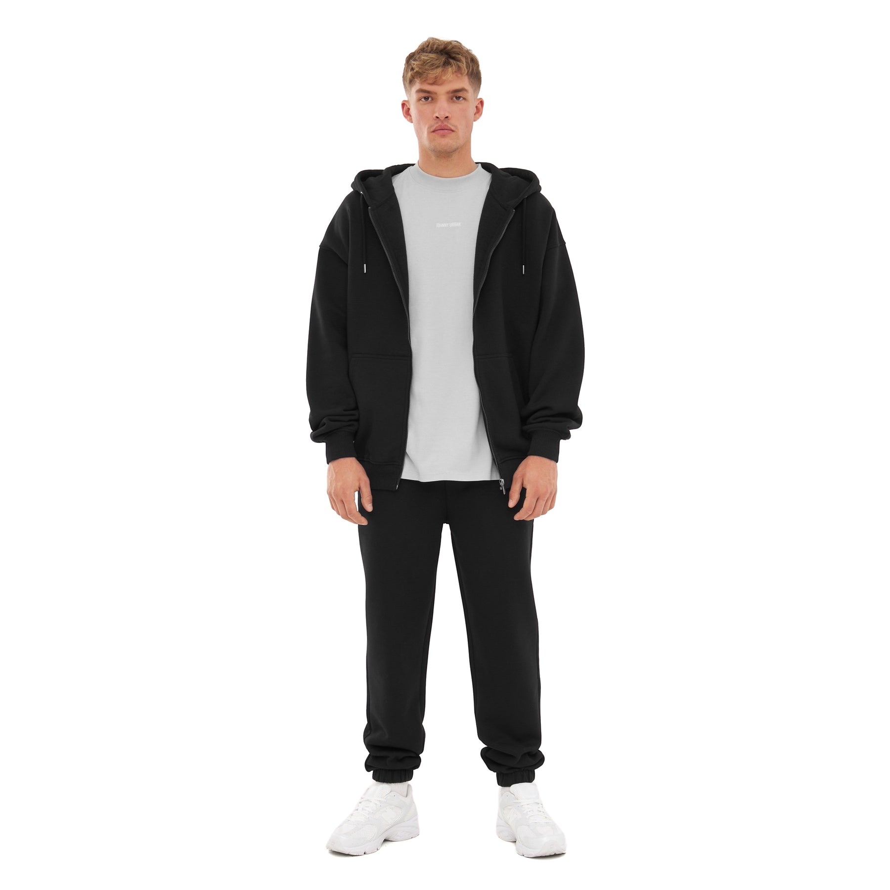 Mann trägt oversized Zip Hoodie 'Caleb' von Johnny Urban in schwarz, dazu schwarze Jogginghose und weißes T-Shirt