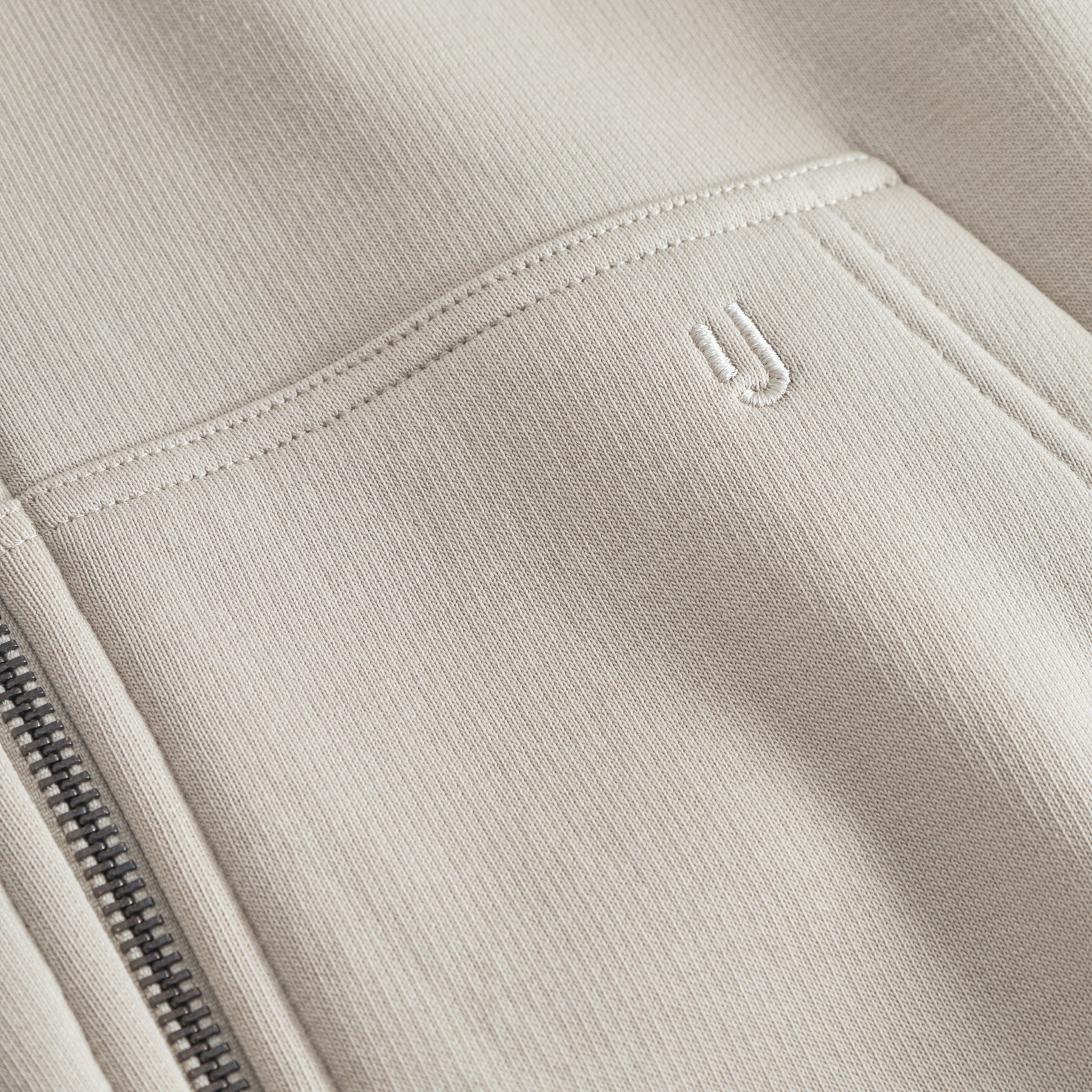 Beiger Oversized Zip Hoodie 'Caleb' mit aufgesticktem 'JU'-Logo an der Vorderseite und Metallreißverschluss