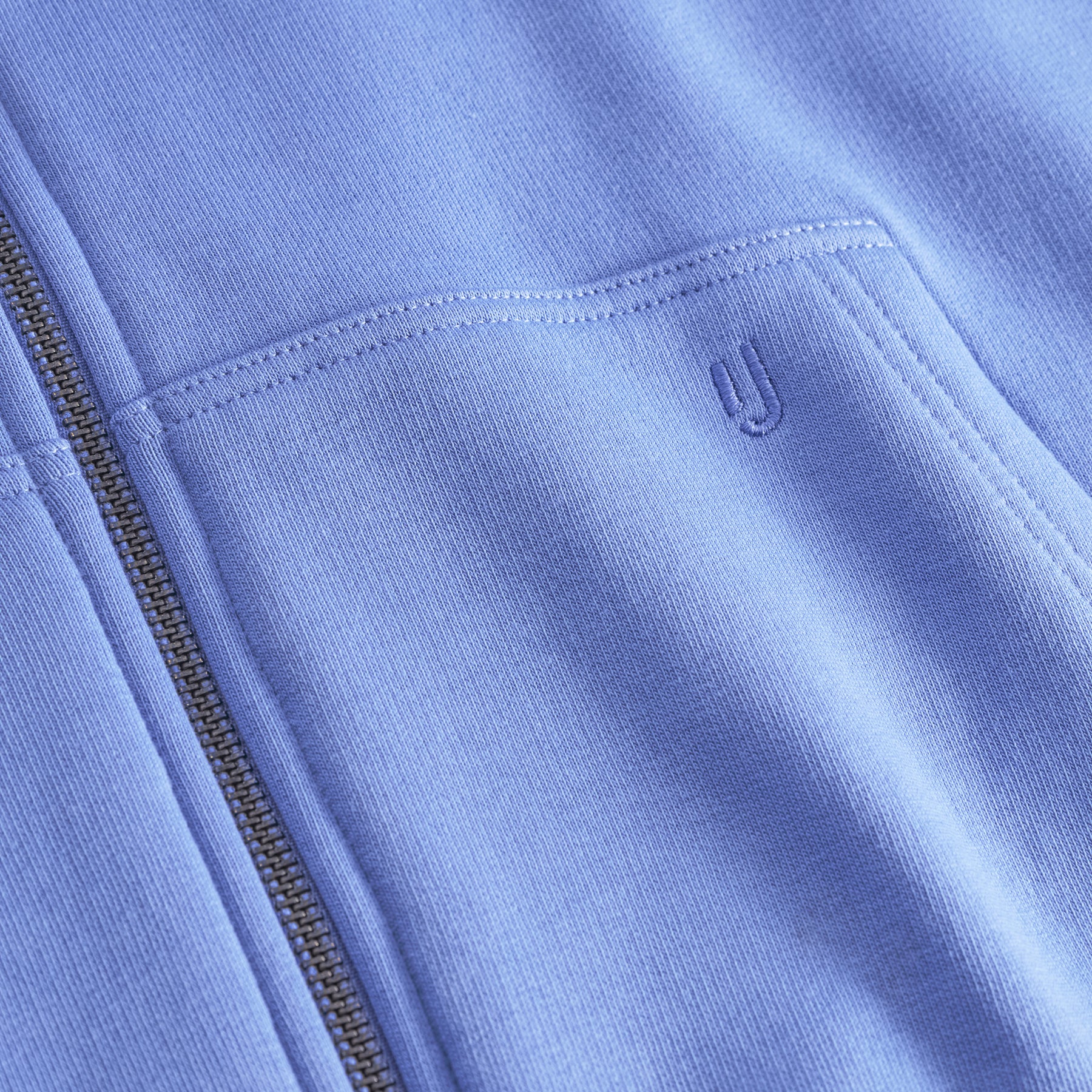 Nahaufnahme der Tasche und des Reißverschlusses des oversized Zip Hoodies "Caleb" in blau-lila von Johnny Urban