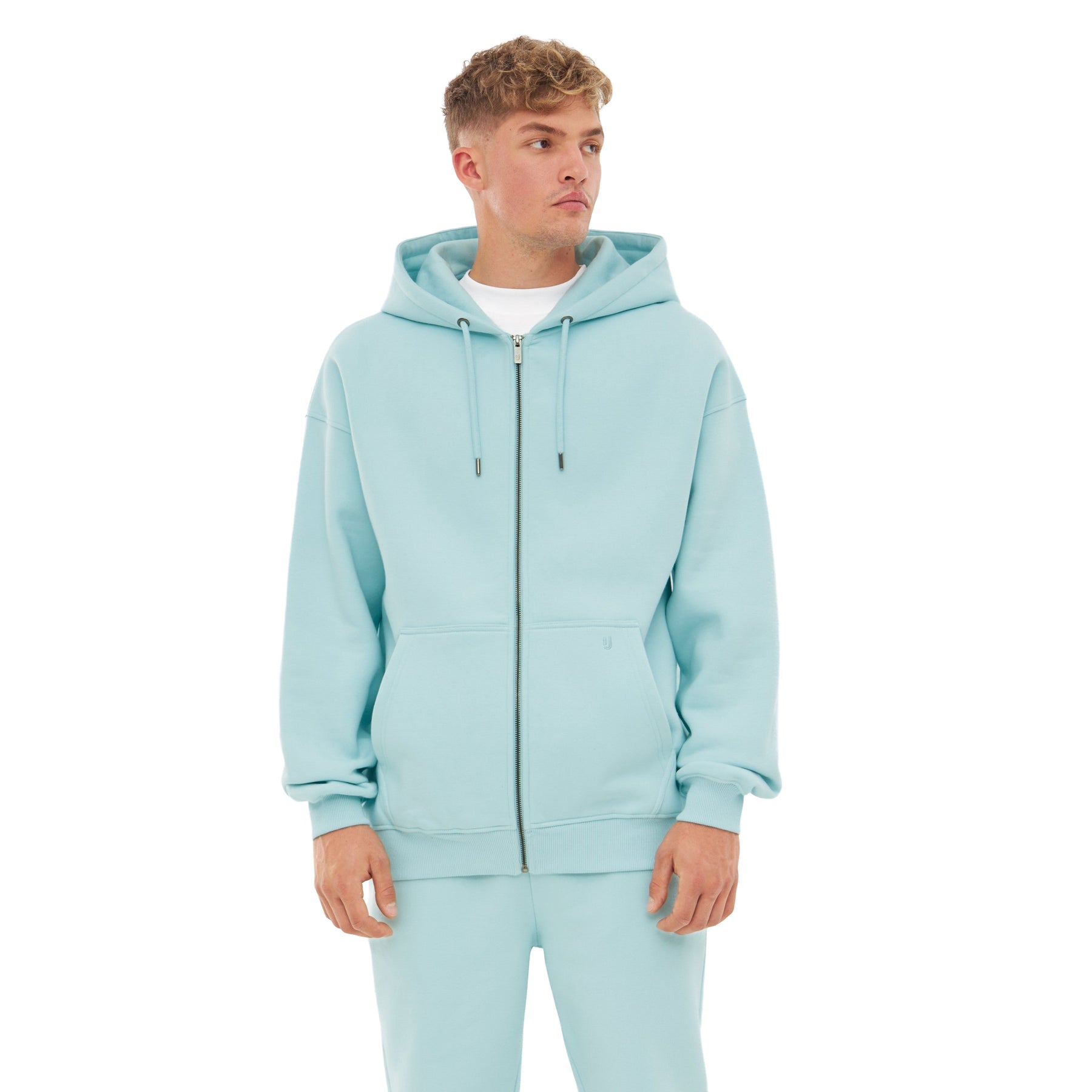 Mann trägt hellblauen oversized Zip-Hoodie 'Caleb' mit Kapuze und Kängurutaschen