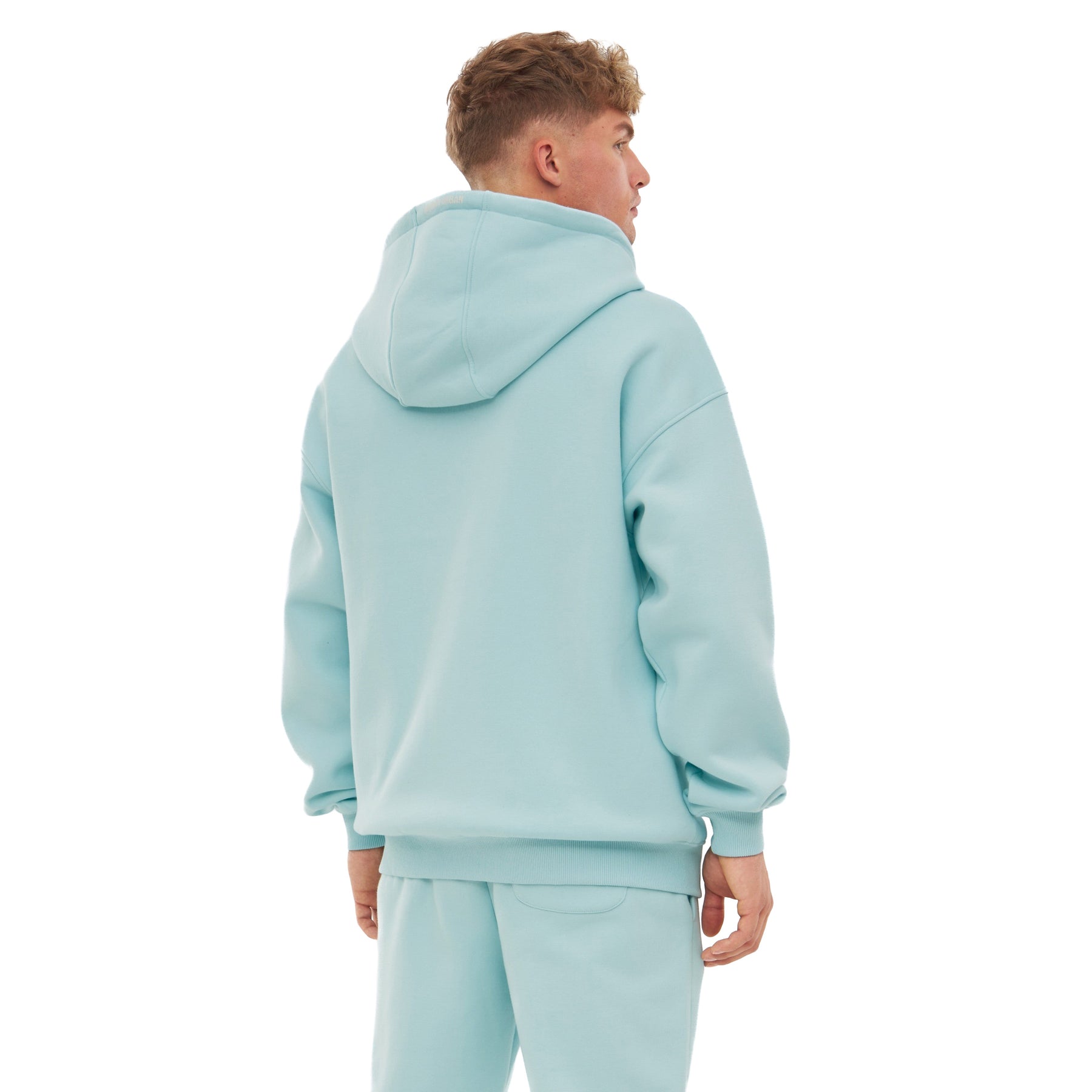Mann trägt oversized Zip-Hoodie 'Caleb' in eisblau von hinten