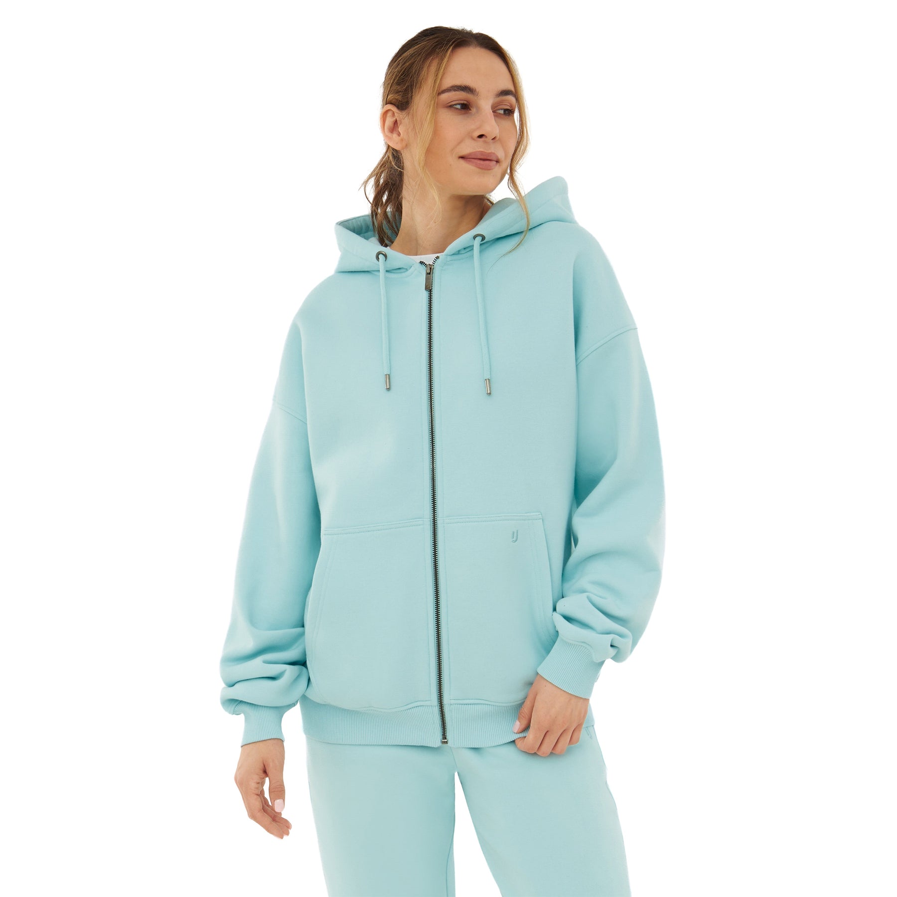 Frau trägt oversized Zip-Hoodie 'Caleb' in modernem Eisblau mit Kapuze und Kängurutasche