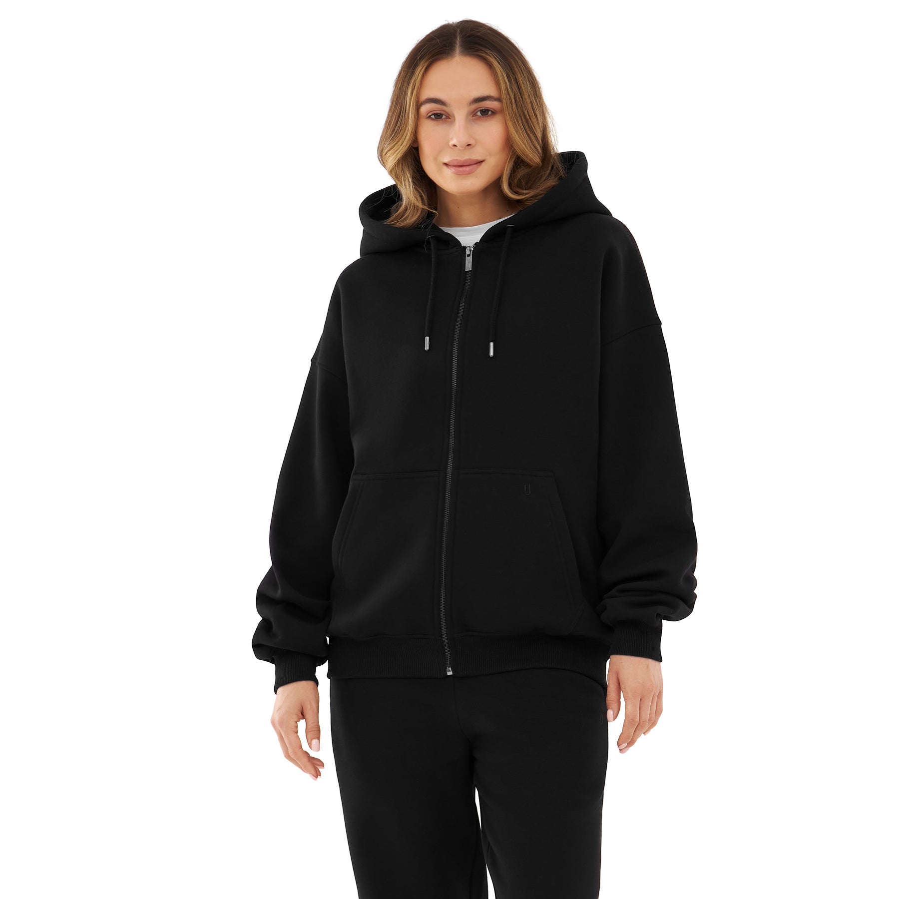 Frau trägt oversized Zip-Hoodie 'Caleb' in Schwarz mit Kapuze und Kängurutasche