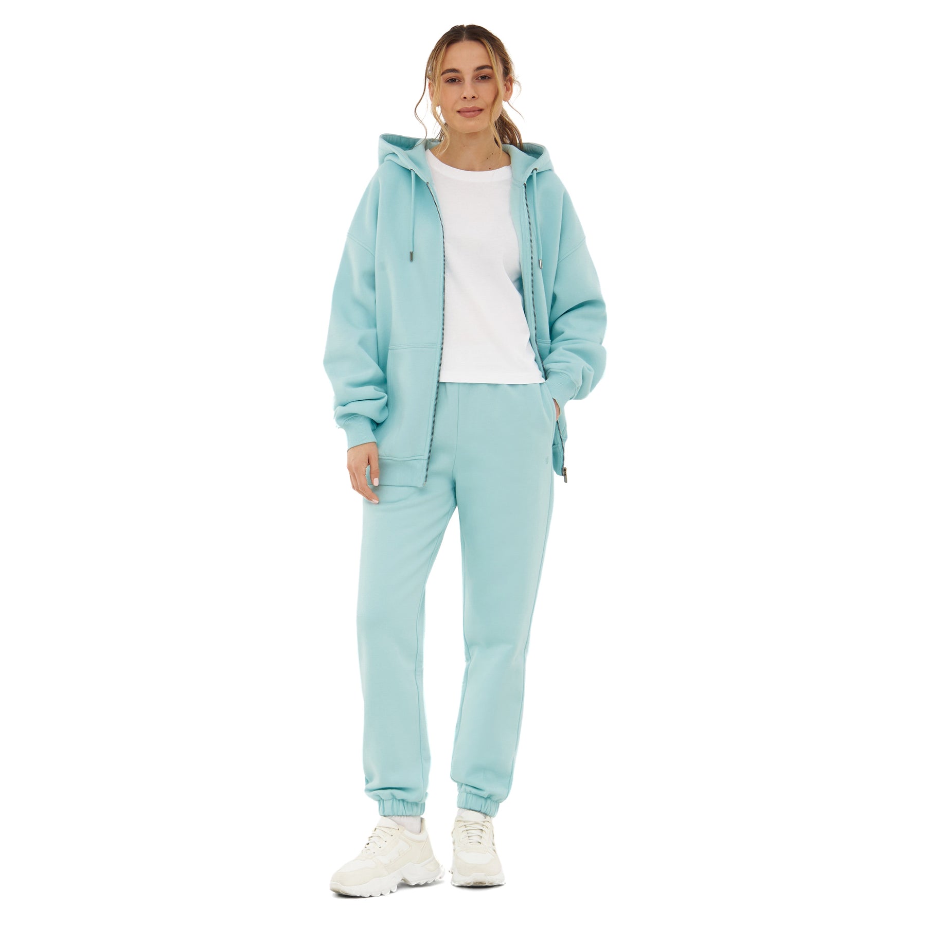 Frau trägt oversized Zip-Hoodie 'Caleb' in Eisblau mit passender Jogginghose und weißem T-Shirt